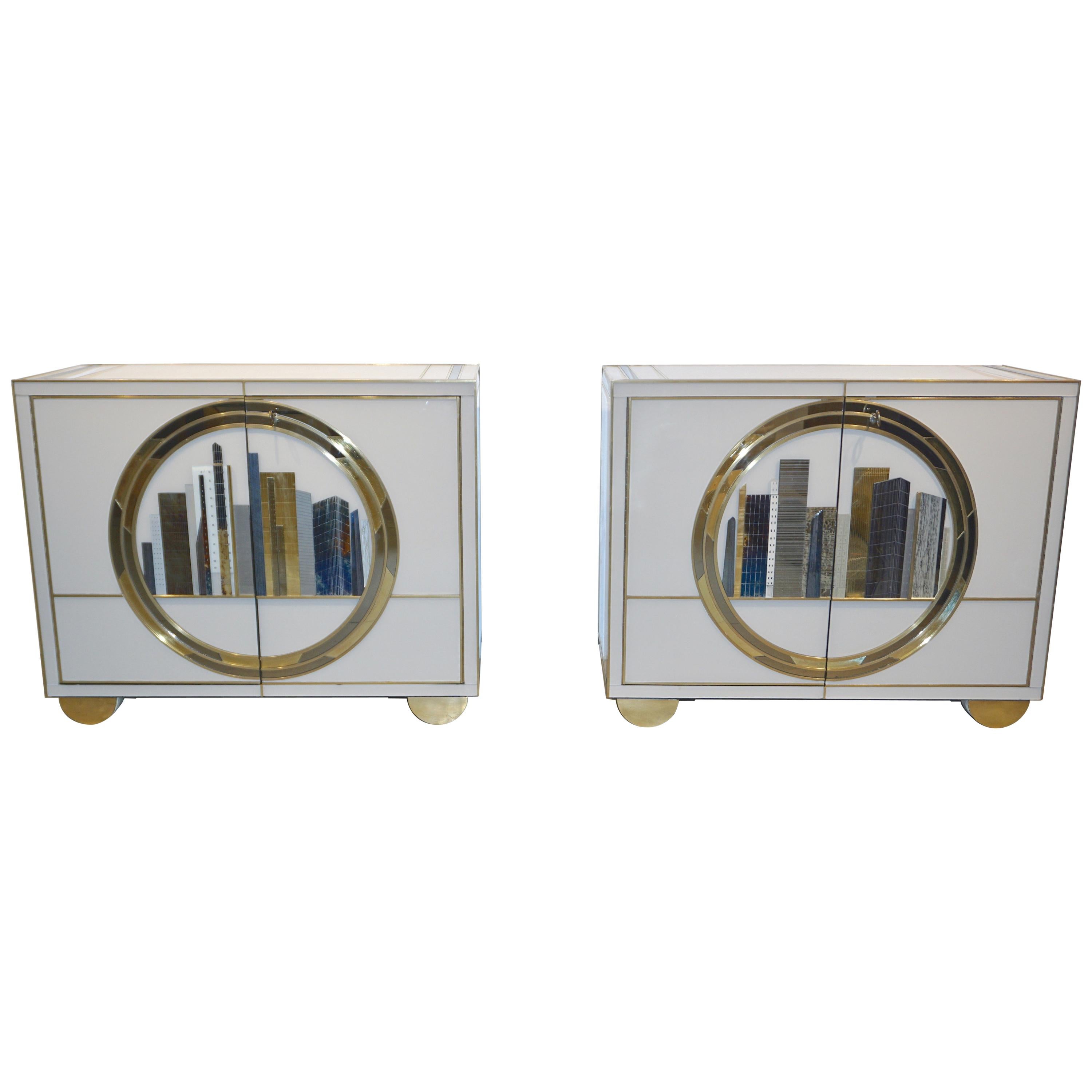 Pair of Italian fine design contemporary one-of-a-kind cabinets, entirely handcrafted with high quality execution. The surround is in cream white glass, each cabinet with an exceptional different decor in the front of a New York skyline glass