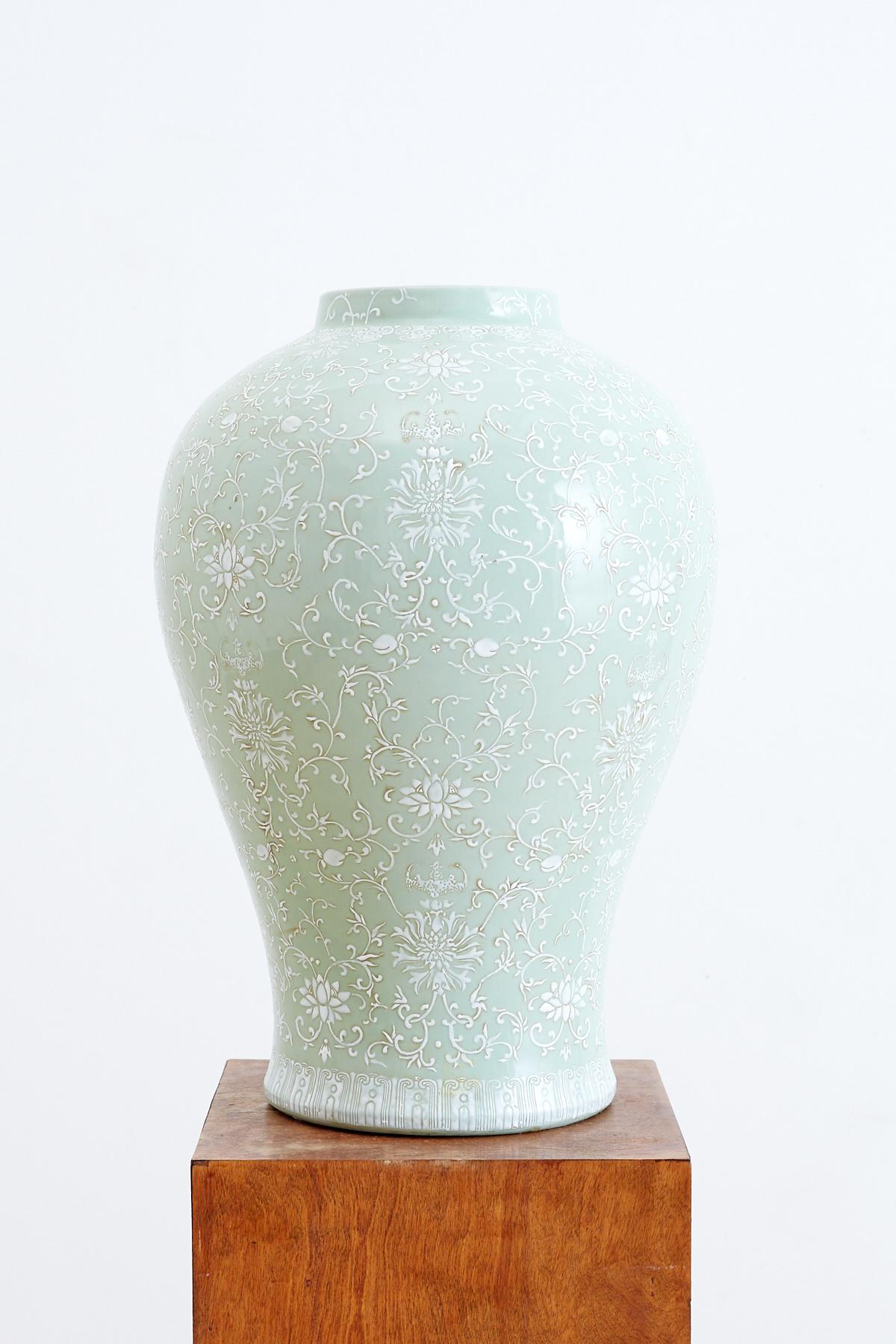 Monumental celadon glazed ginger jar form vase featuring a moriage or dragon ware decoration. Nearly 15 inches wide and 25 inches tall this large jar has a unique raised white floral and foliate decoration. Beautiful intricate patterns run