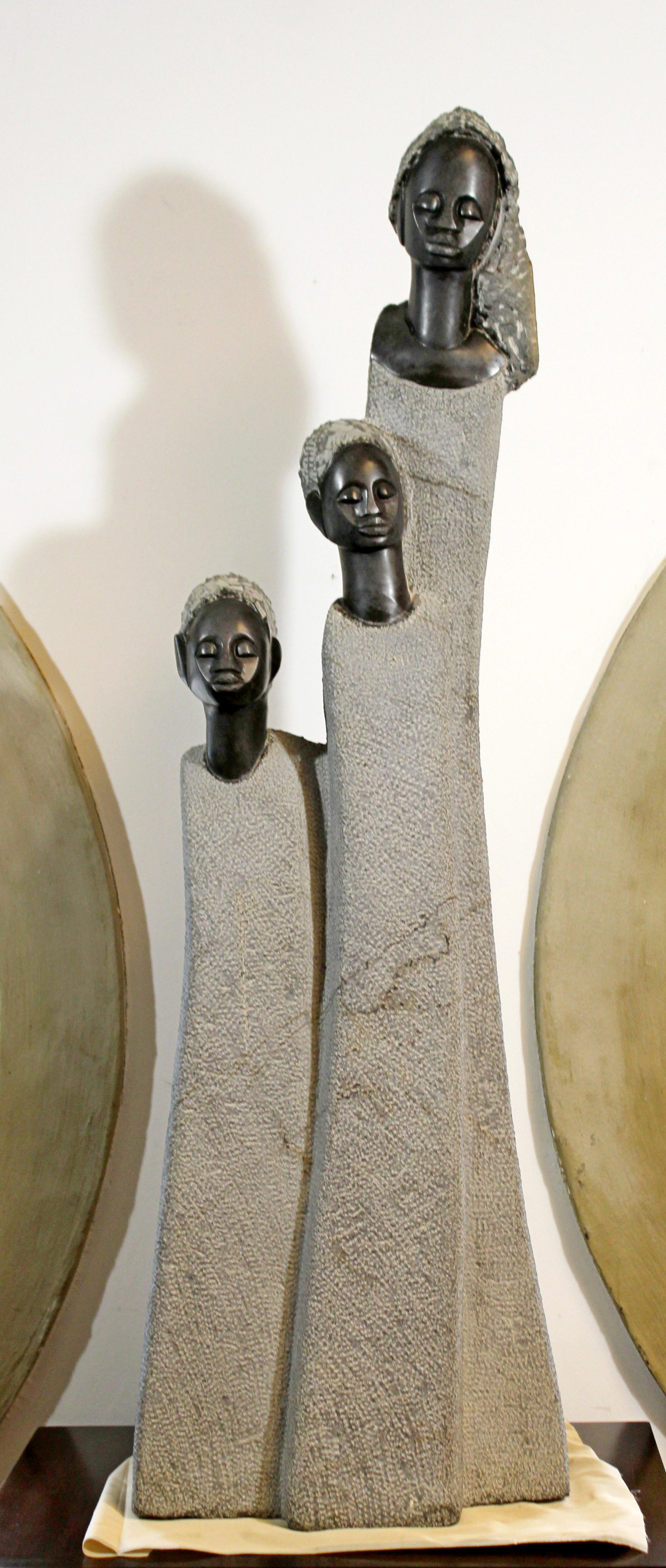For your consideration is a breathtaking, stone sculpture of three heads, on a wooden base pedestal, signed by Zimbabwean sculptor Joe Mutasa. In excellent condition. The dimensions of the sculpture are 14