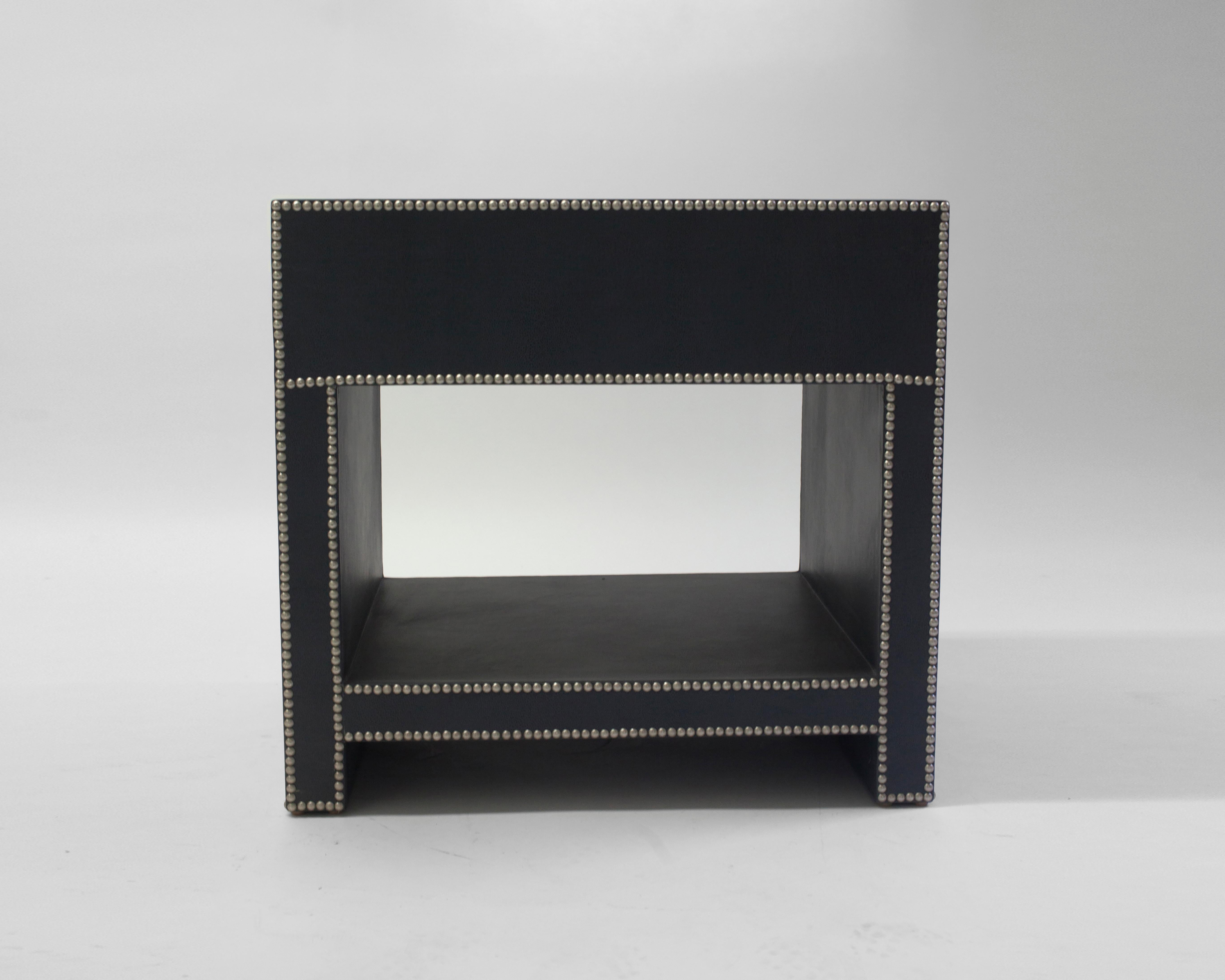 Der Keap Nachttisch von LF upholstery zeigt, dass Funktionalität auf Stil trifft. Wunderschöner, handgefertigter Holzrahmen mit Lederpolsterung und Zinnnagelverzierung. Abgebildet mit einer Schublade und einem offenen Regal zur Aufbewahrung.
DER