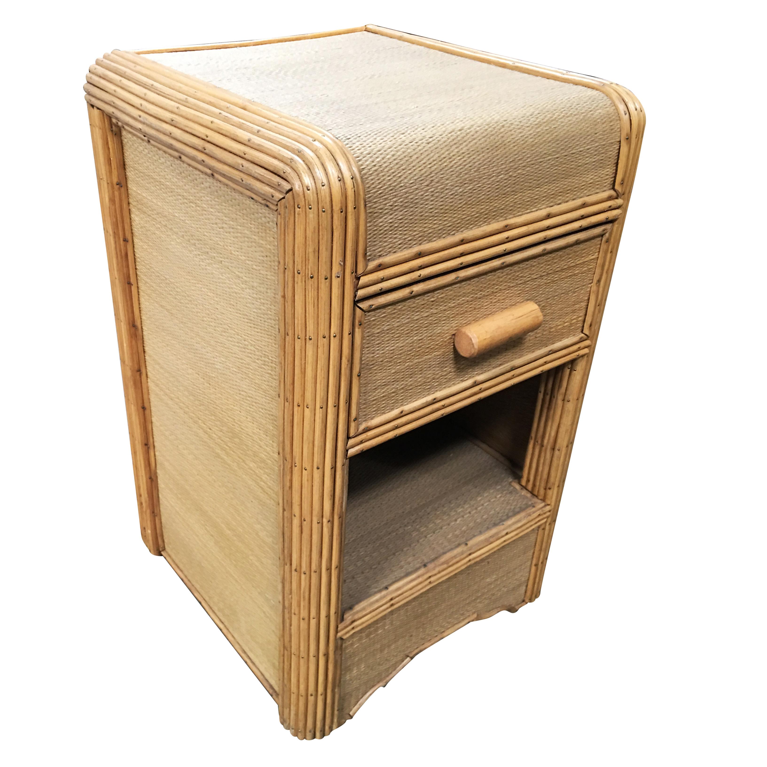 Streamline stick rattan side table nightstand with grass-mat coverings, edges are finished with brass nails.

Restored to new for you.

All rattan, bamboo and wicker furniture has been painstakingly refurbished to the highest standards with the best