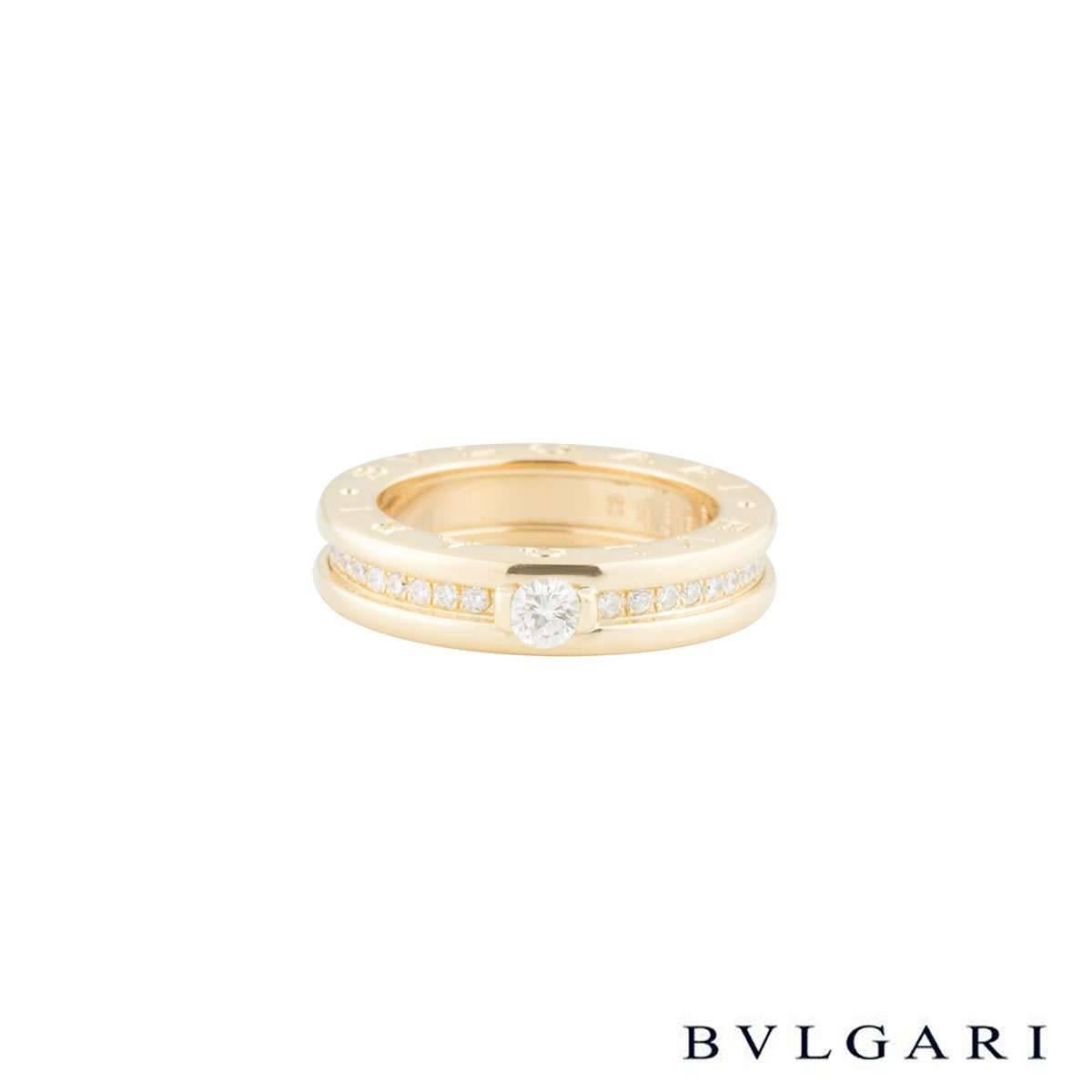 An 18k yellow gold diamond set Bvlgari ring from the B.Zero1 collection. Set to the centre of the ring is a 0.30ct round brilliant cut diamond in a rubover setting, F in colour and VVS2 in clarity. Accentuating the central stone on either side are