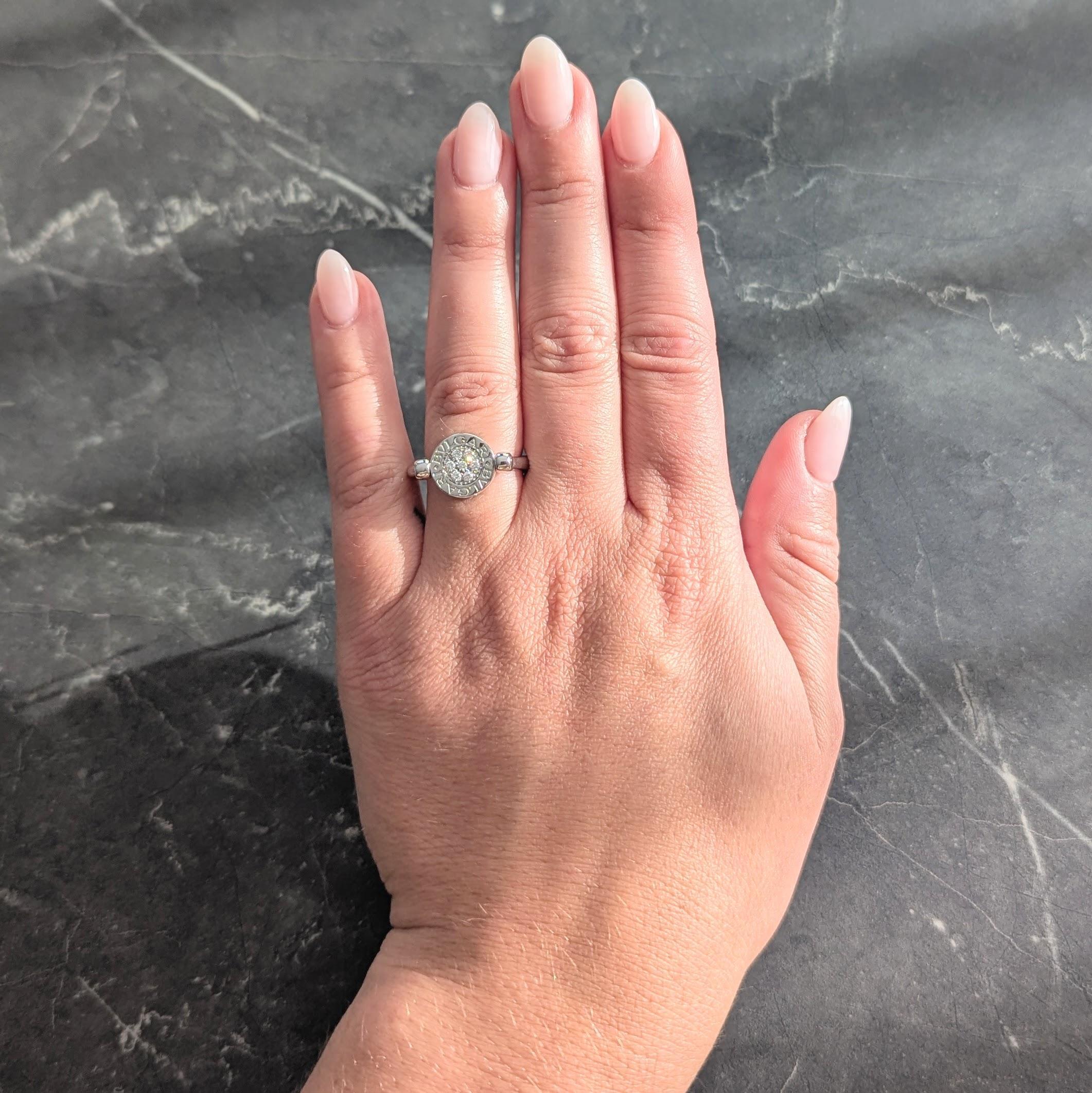 L'anello stile Signet centra un disco circolare di 11,0 mm che ruota su un asse.
Un lato è incastonato con diamanti rotondi taglio brillante a grappolo.
Peso totale di circa 0.20 carati - occhi puliti e luminosi
L'altro lato è intarsiato con una