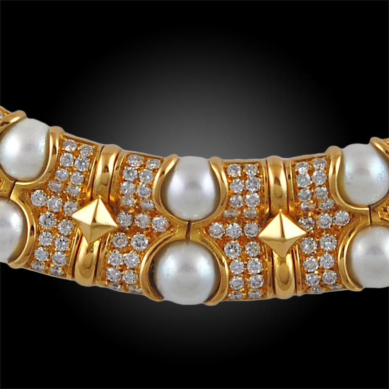 A resplendent 1990's collar necklace by Bulgari, finely crafted with several rows of beaming pave-set brilliant-cut diamonds alternating with rows of round cultured pearl borders.  
In the 1990's, Bulgari was known for creating pieces that we more