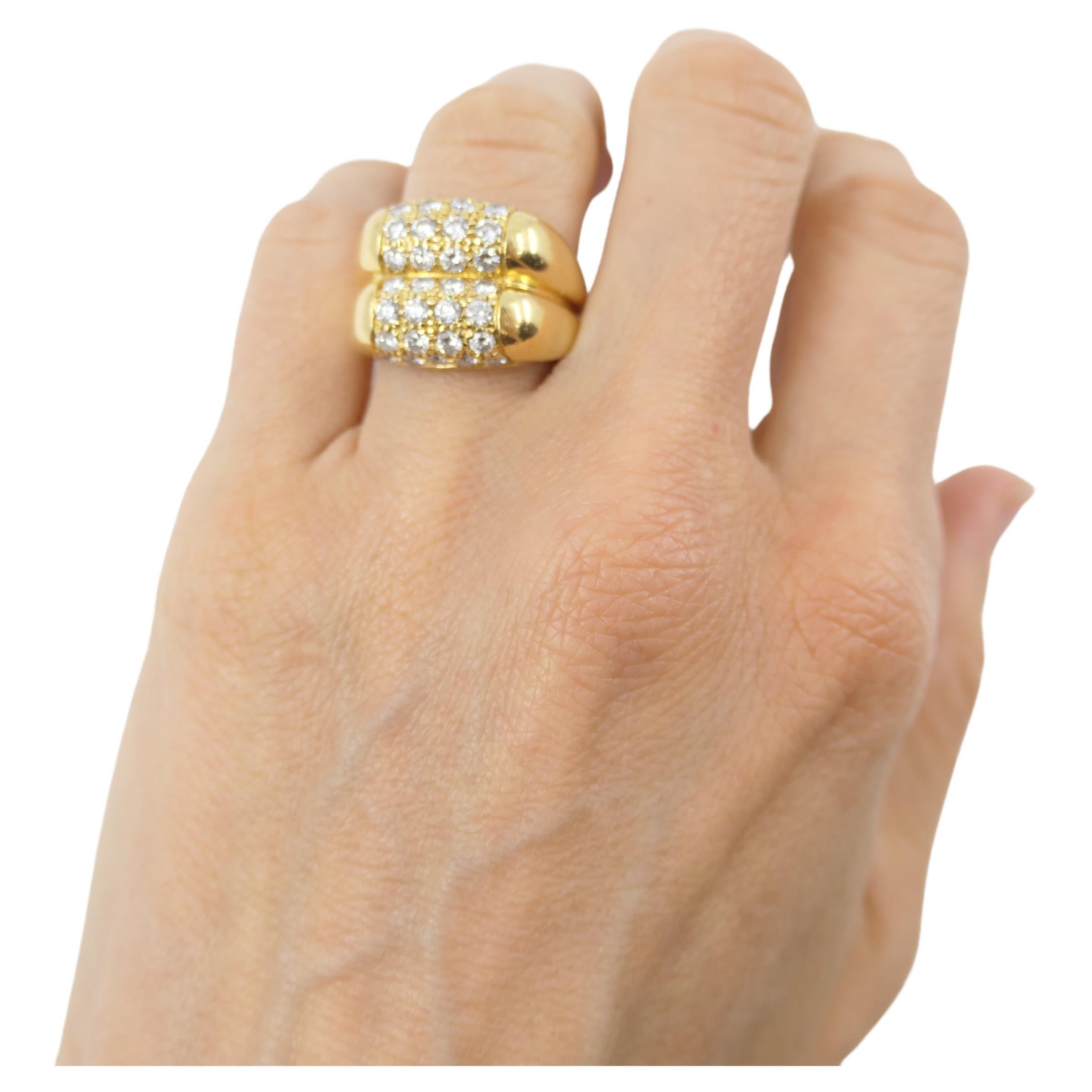 A double Tronchetto ring by Bulgari, made of 18k gold, features diamonds. It's designed as two Tronchettos being put on top of one another. The diamonds are pave, arranged in straight lines of four gems. The ring's design is minimal, yet it looks