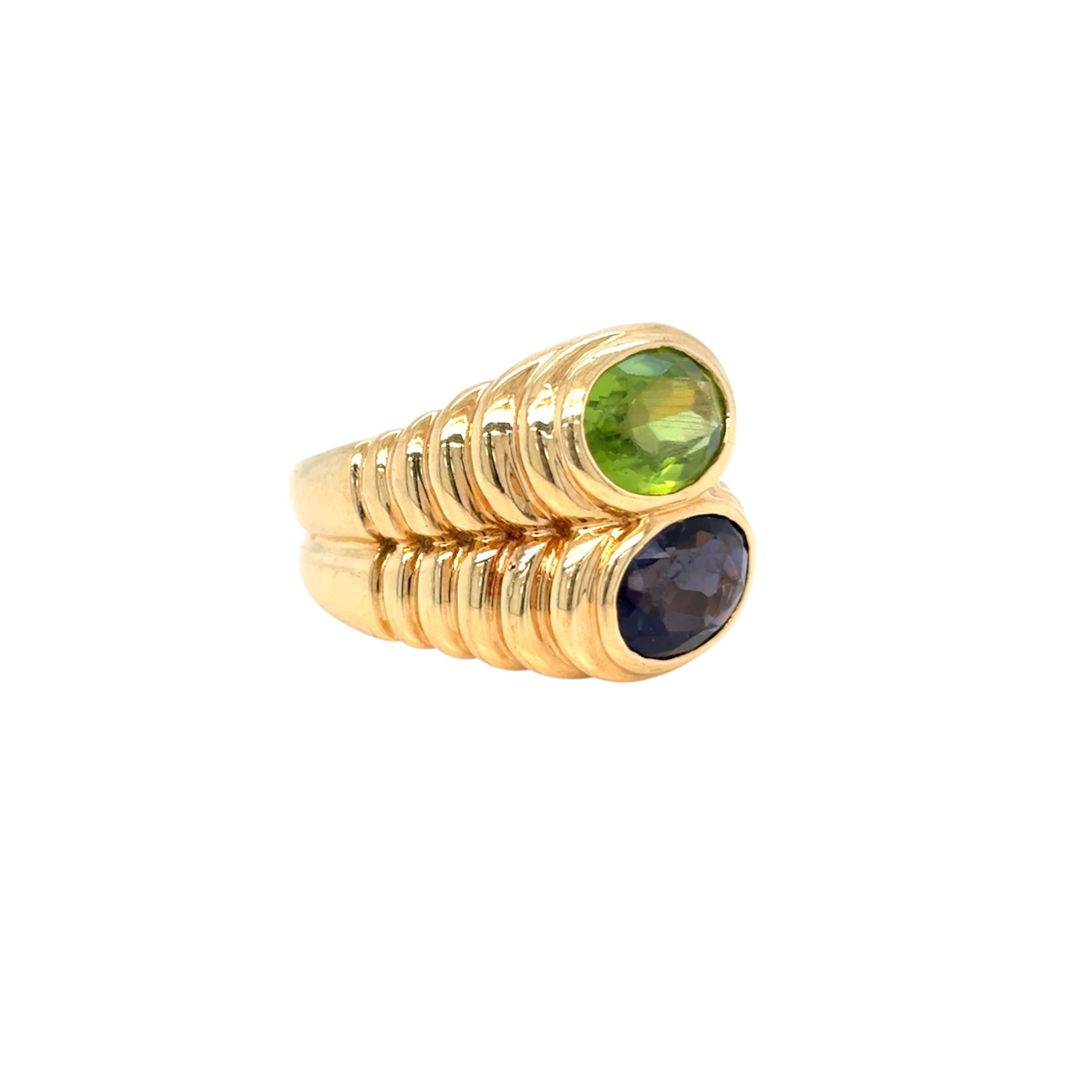 Der ikonische Ring Doppio Baccellato von Bulgari ist aus 18er Gelbgold gefertigt und mit einem natürlichen ovalen blauen Peridot & Iolith besetzt. CIRCA 1980'
Größe 6, Größenänderung auf Anfrage, Gesamtgewicht 12 Gramm

Gestempelt mit der