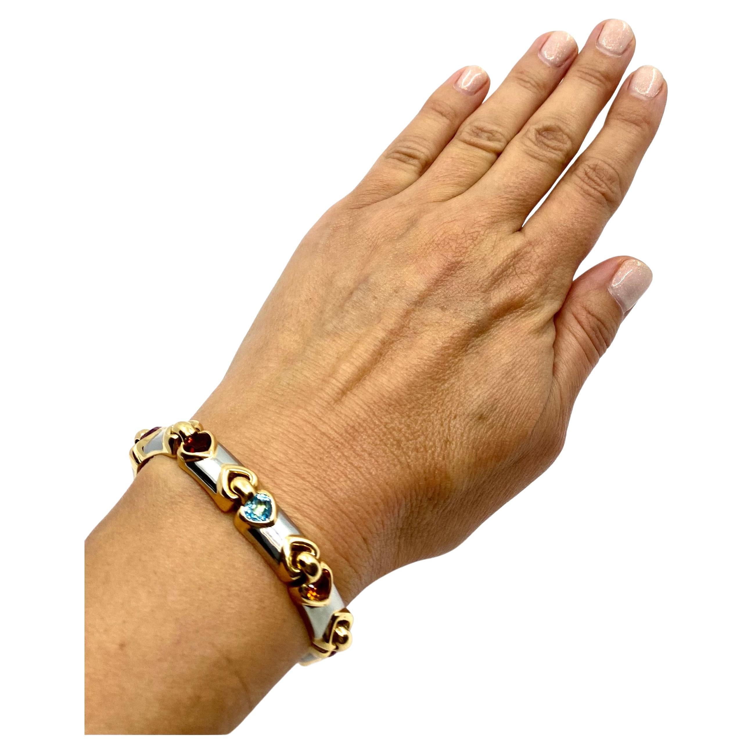 

 A two-tone gold bracelet by Bulgari, from the Doppio Cuore collection. The bracelet features following gemstones: tourmaline, garnet, topaz and citrine. This Doppio Cuore bracelet consists
of nine rectangular links. Each link is adorned with a