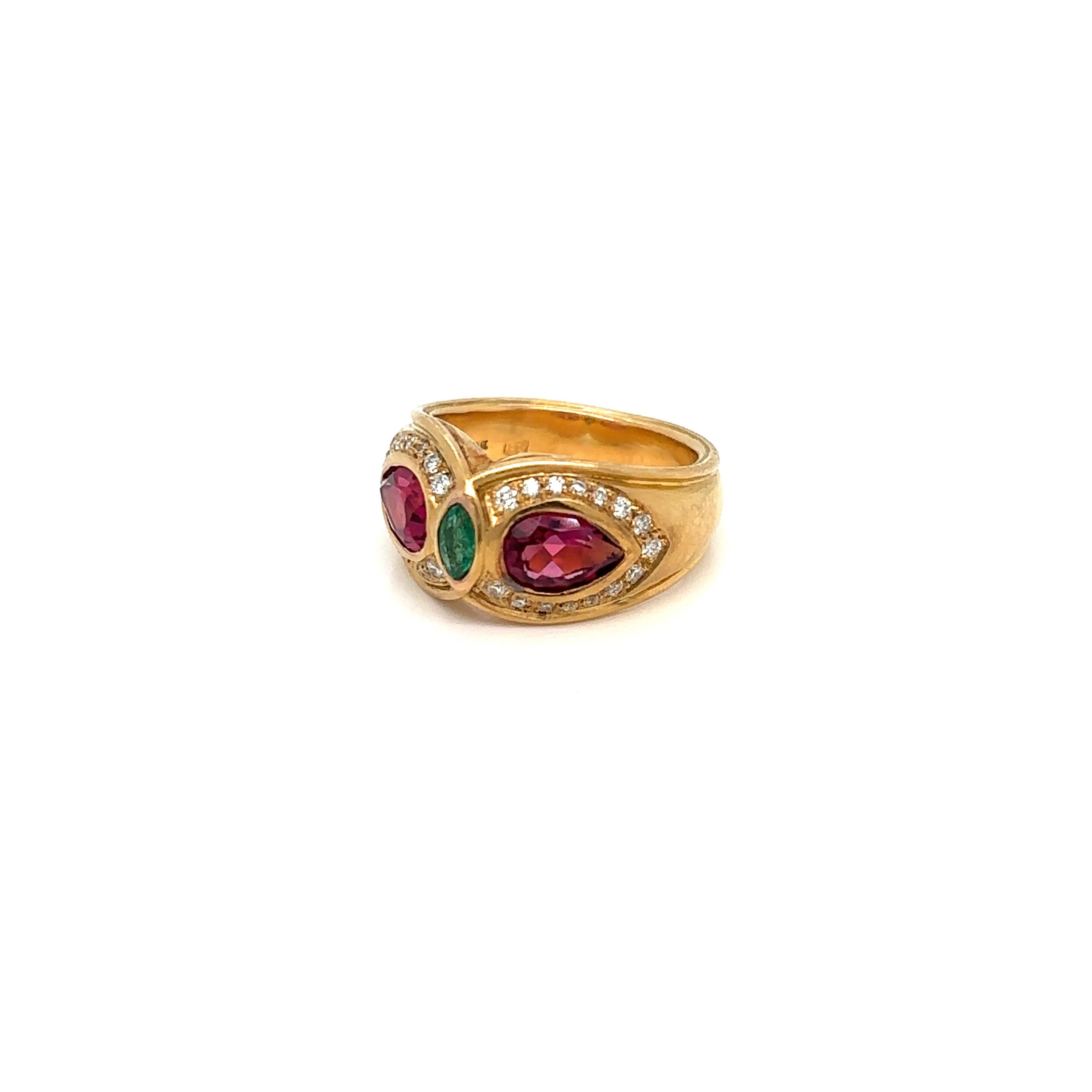 Timeless ring created by Bulgari in France in 1970 circa. The set is made of 18 karat yellow Gold, two sparkling Tourmalines drop, one fine Emerald marquise shape in the center and colorless diamonds.
Stamped BVLGARI, with the maker's mark, the