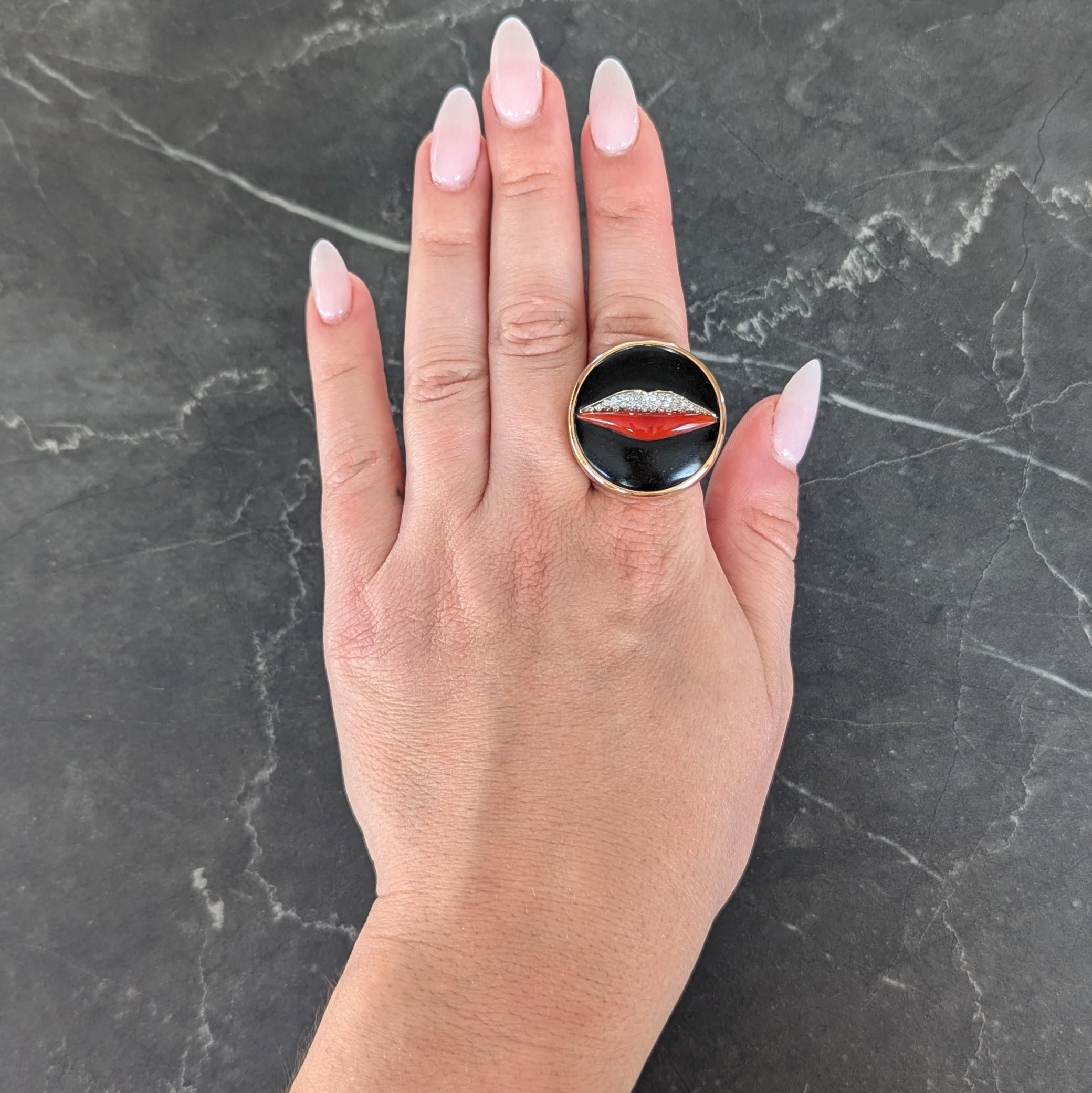 Featuring a 25.0 mm round carved jet plaque - opaque black with subtle grain
Centering dimensional lip forms comprised of a pavé set diamond upper lip
Round brilliant cut and weighing approximately 0.20 carat total - eye clean
Bottom lip is made of