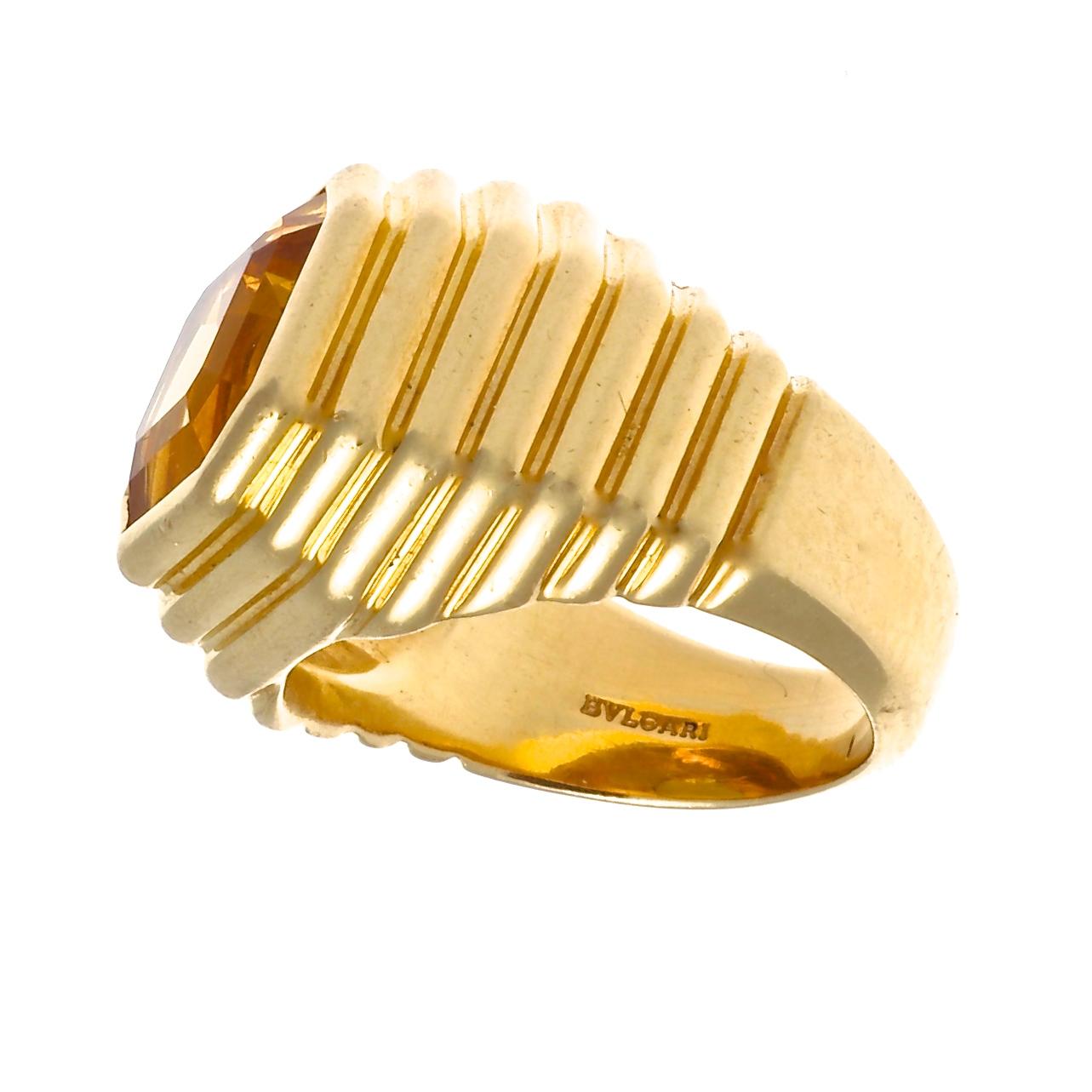 The beauty and elegance of Bulgari is uniquely expressed in this layered gold and citrine ring. The beautiful square emerald cut citrine is a dark golden color and is snugly set in rich 18k gold. Ring size is 5 and comes with complimentary ring