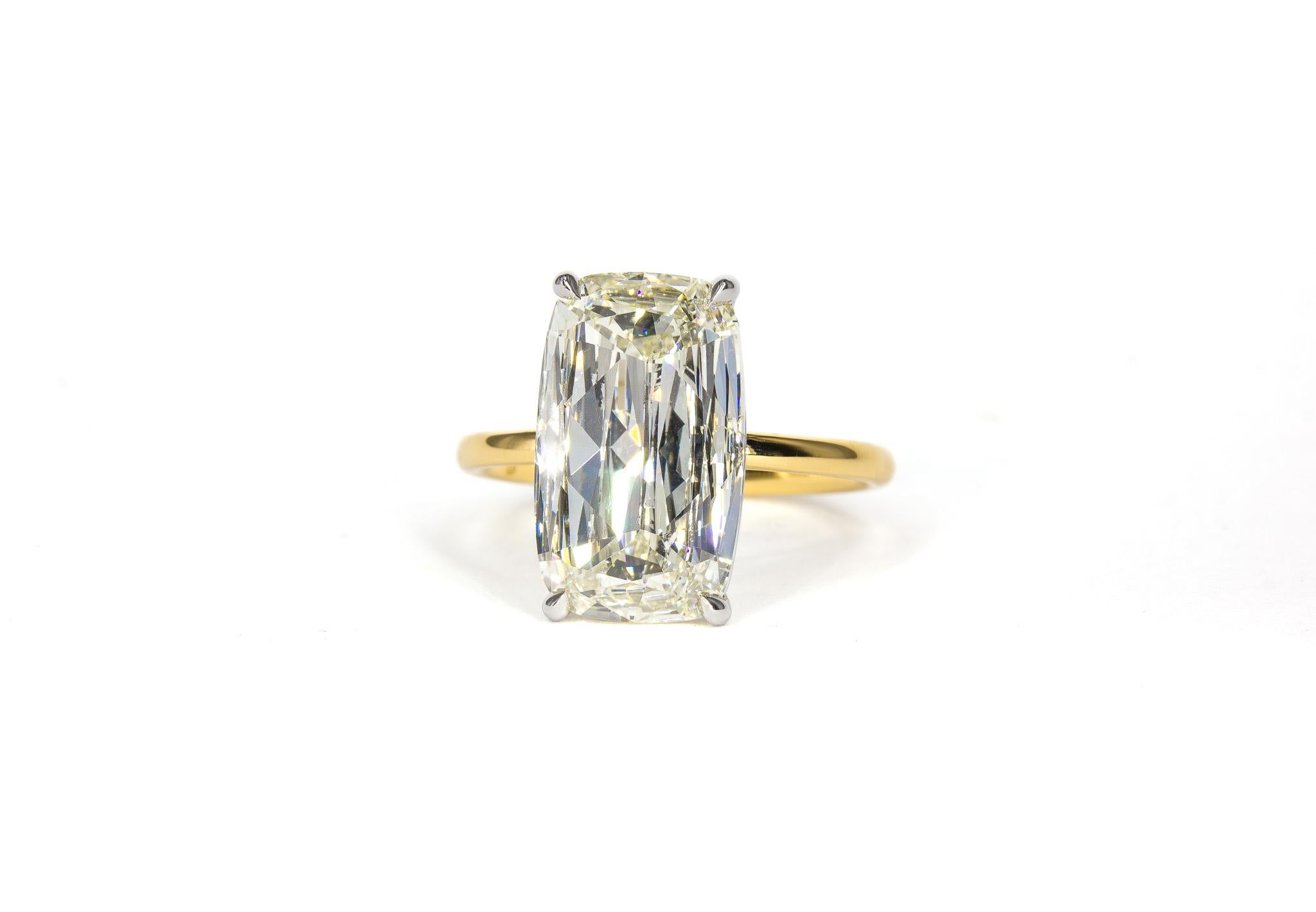 
This elegant platinum and 18K yellow gold solitaire ring is a timeless statement of sophistication and charm. Showcasing a stunning 4.01 carat old elongated Ashoka style cushion cut diamond, graded M SI2 by GIA, the center stone radiates warmth and