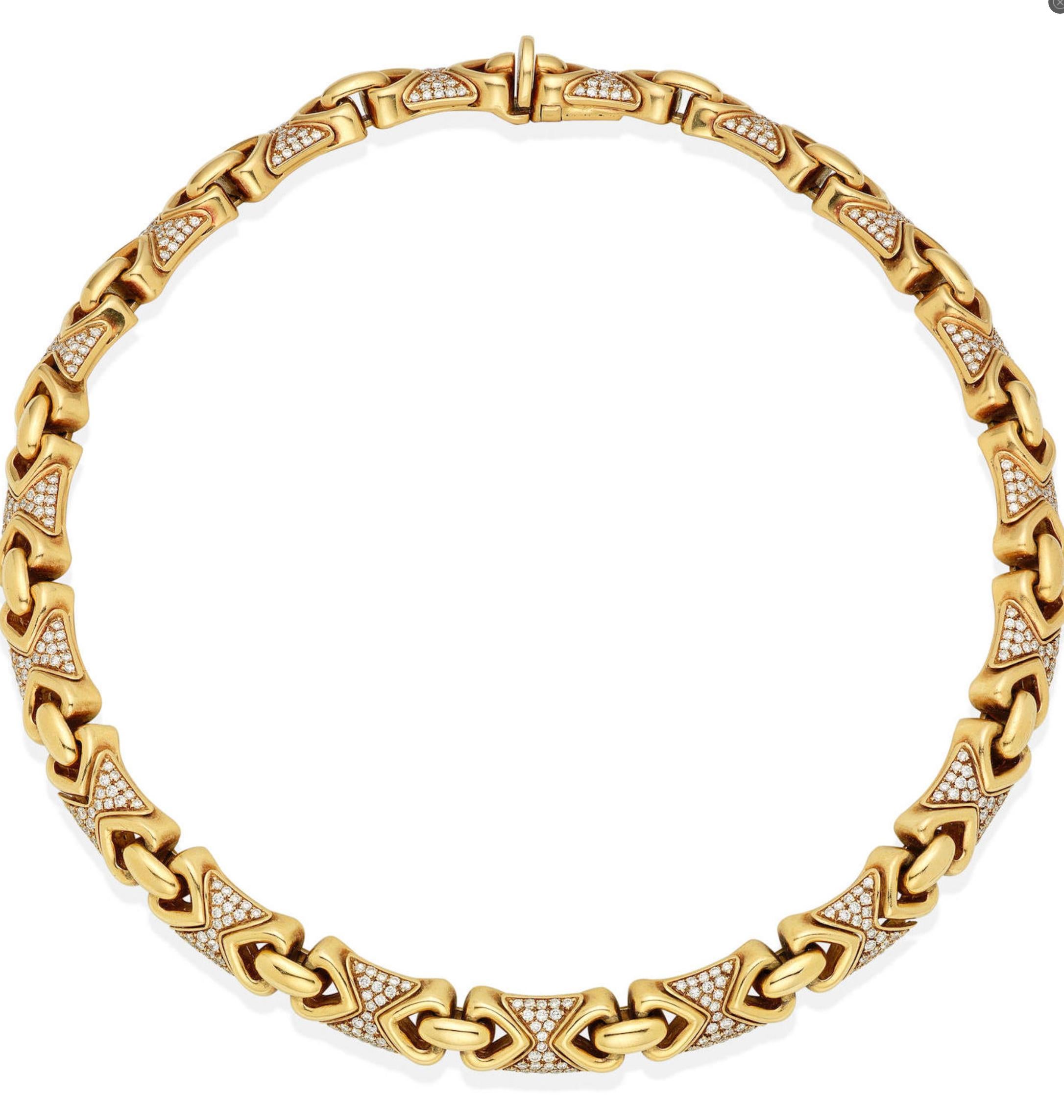 A diamond set 'Doppio Cuore' 18 karat yellow gold necklace by Bulgari designed as a series of modular-links pave'-set with Round Brilliant cut Diamonds weighing approximately 4.40 carats with alternating triangular-shaped polished links.  The