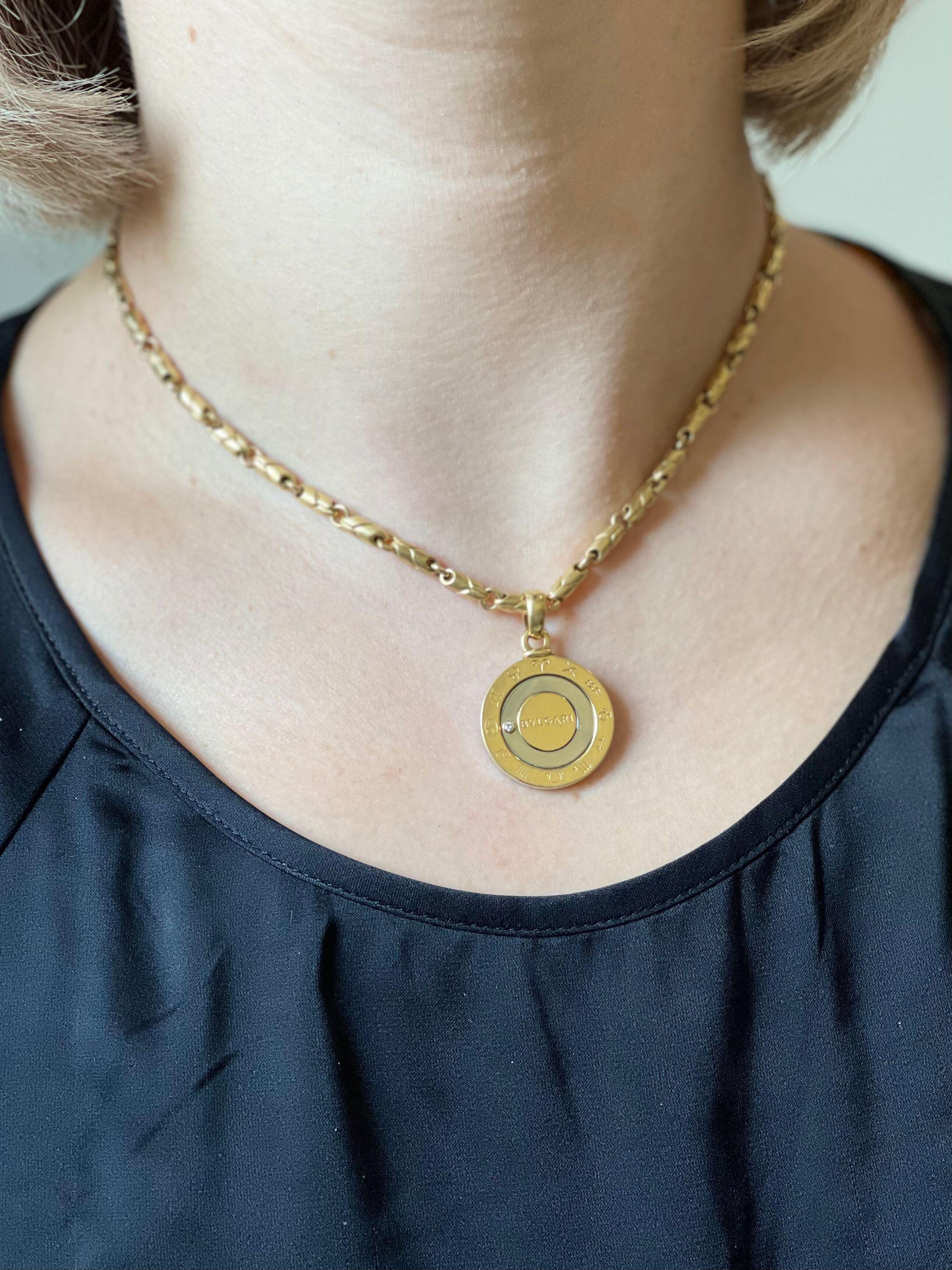 18k gold and stainless steel Zodiac pendant on an 18k gold chain necklace, both crafted by Bvlgari. Pendant depicting all 12 Zodiac signs, with one G/VS diamond. Necklace is 15.75