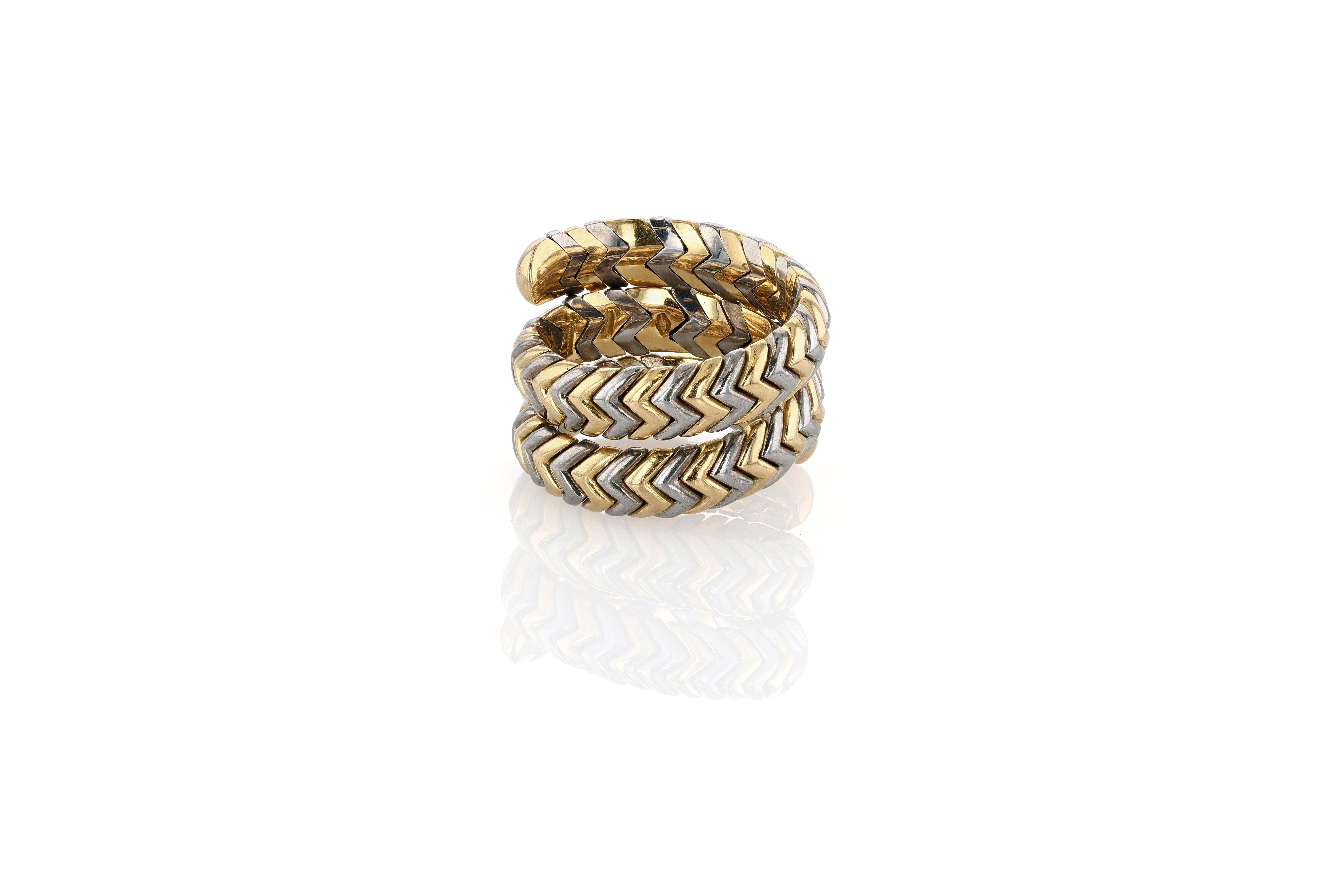 A vintage and quite rare Bulgari Spiga triple wrap ring, finished in Bulgari's signature combination of stainless steel and 18 karat yellow gold. The ring features a high polish finish, but because of the gray tone of the stainless steel, retains a
