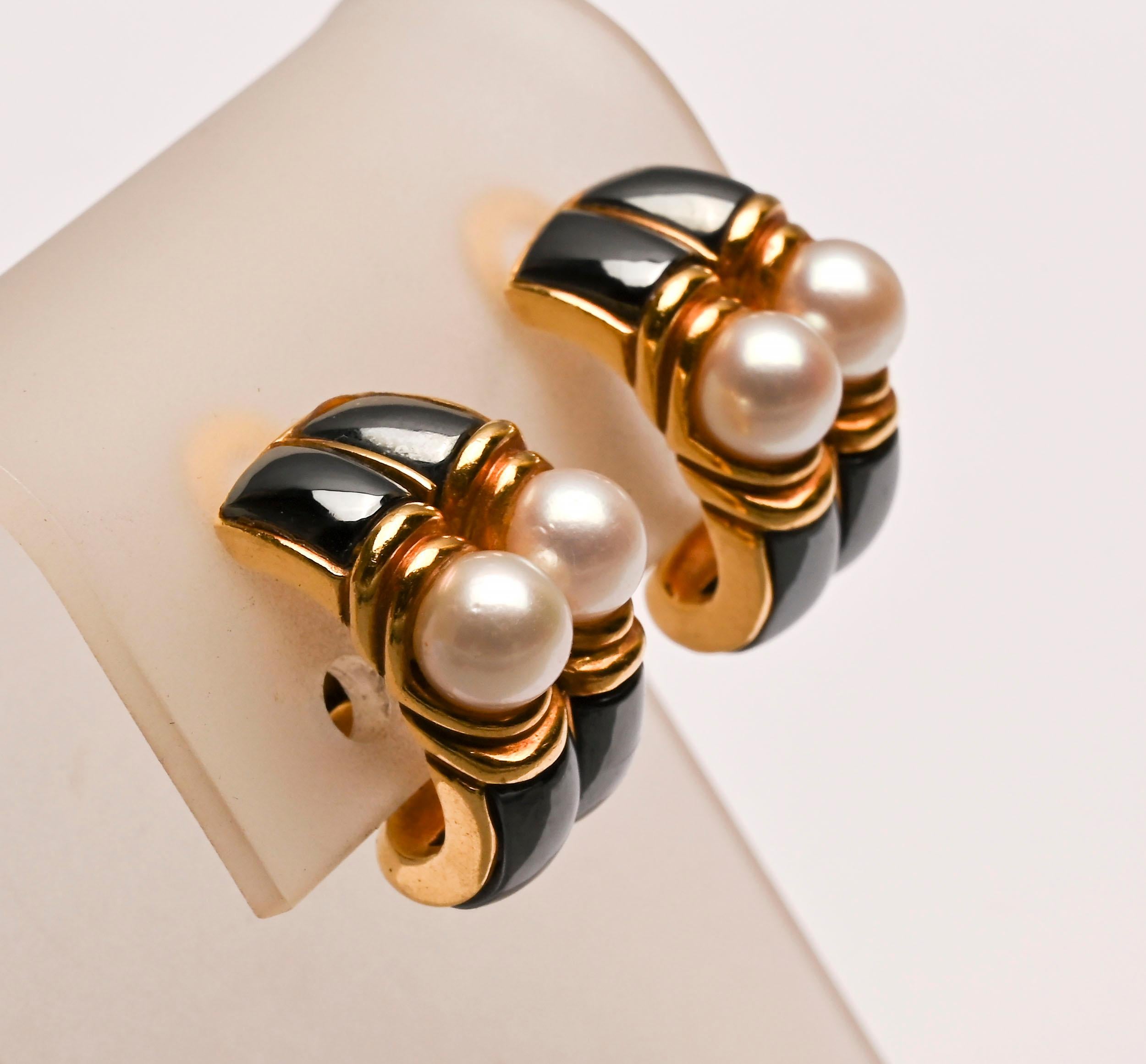 Sophisticated and sporty pearl and hematite earrings by Bulgari. Each earring has two pearls that are approximately 6.5mm in size. They are cradled in a two part band of gold. Rectangular plaques of hematite are above and below. Clip backs can be