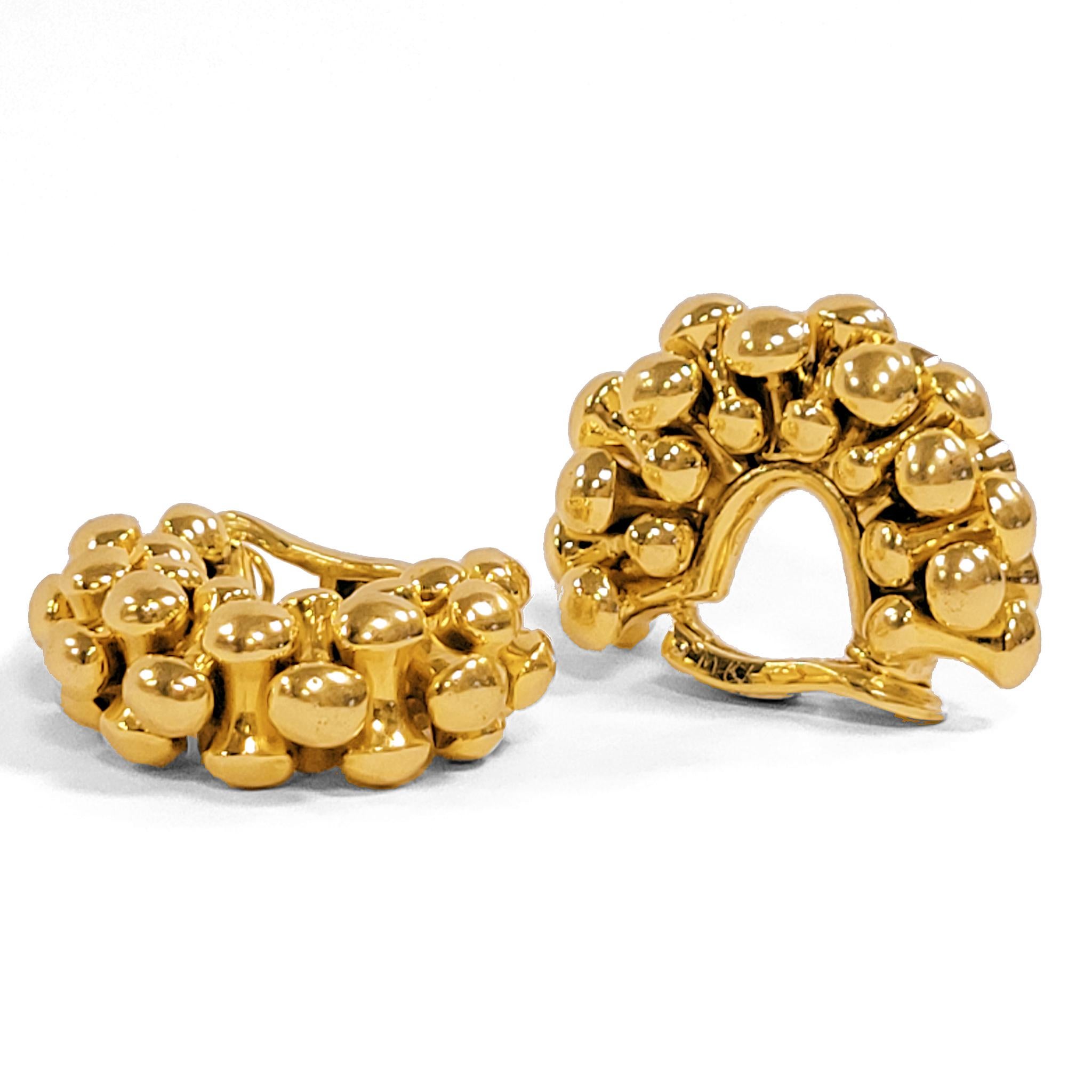 Created by Bulgari Rome, these late 20th century half hoops clipback earrings are composed of gold. Each half hoop is designed as alternating rows of interlocking ovoids oriented frontally and sideways. These gleaming gold hoops, with their unusual