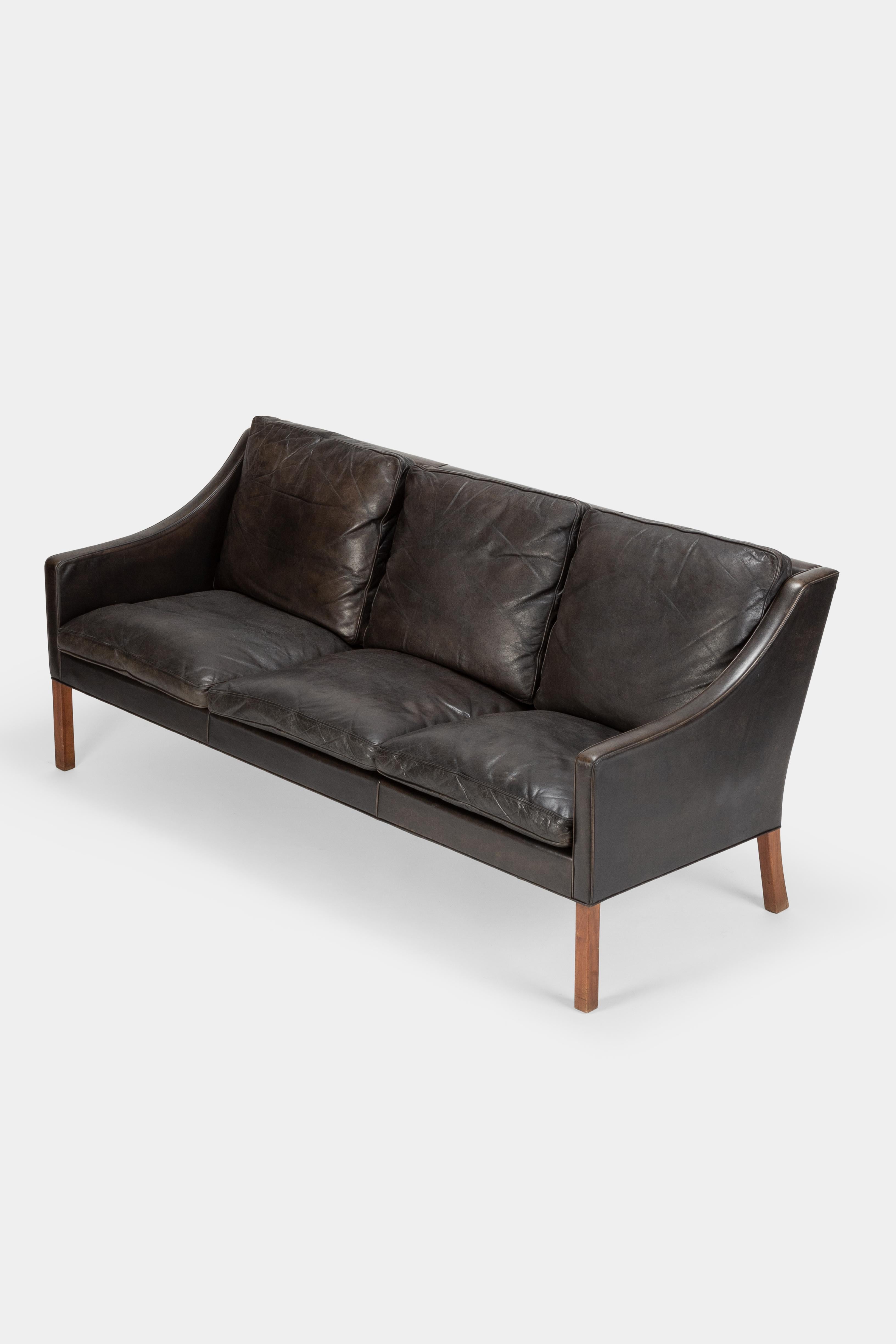 Borge Mogensen 3-seat sofa model 2209 manufactured by Fredericia in the 1960s in Denmark. Covered with black leather which has a stricking patina. The legs are made of solid oak wood.