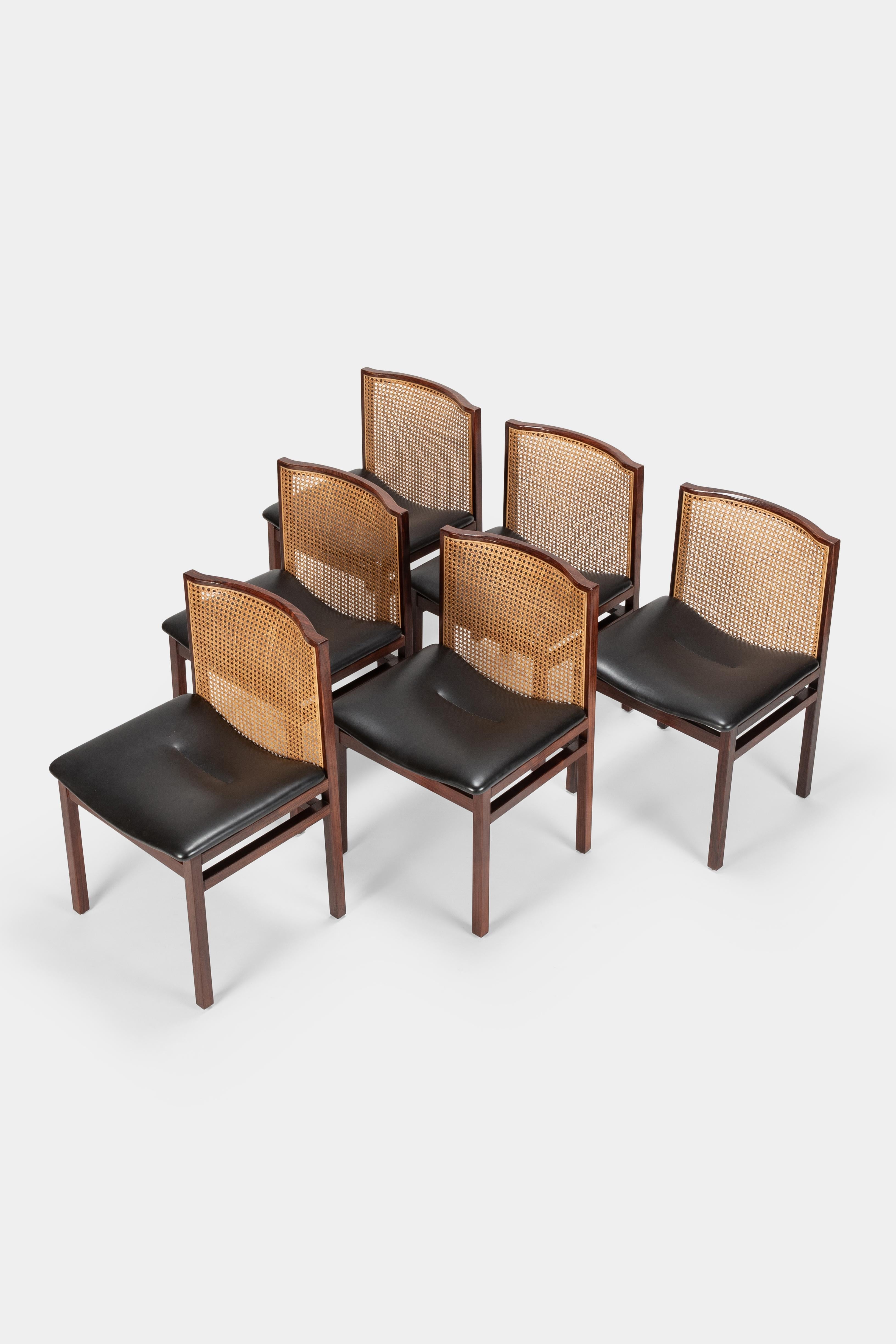6 Tito Agnoli dining room chairs manufactured by La Linea in the 1960s in Italy. Comfortable seats covered with fine black vinyl leather. Cane back rest attached to a solid rosewood frame.