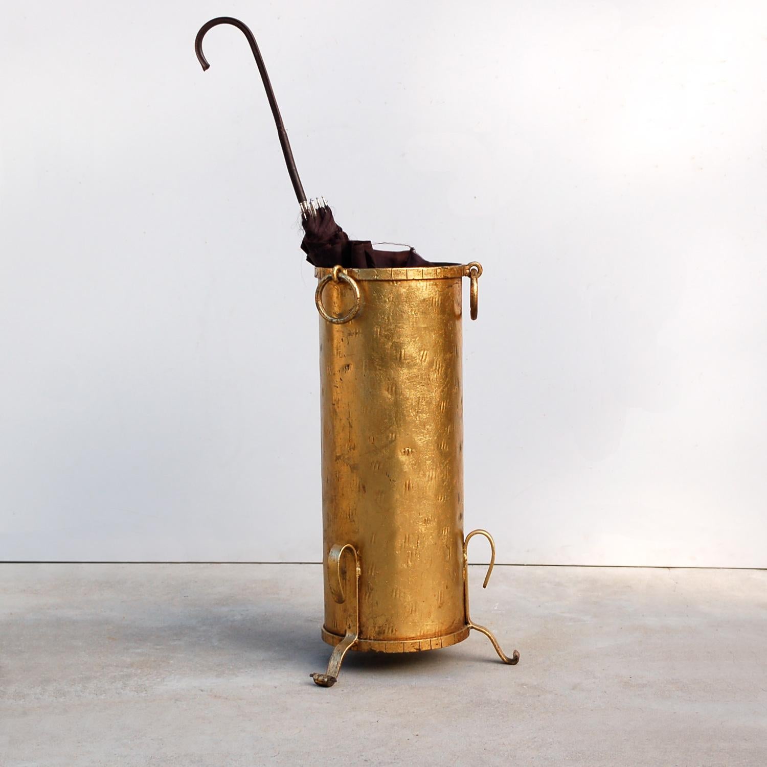 Late 20th century gold colored, gilt, gilded umbrella or stick stand in a rustic, country, farmhouse style with a hint of Hollywood Regency flair due to the gold finish. The metalwork has been lightly hammered for decorative effect with banding on