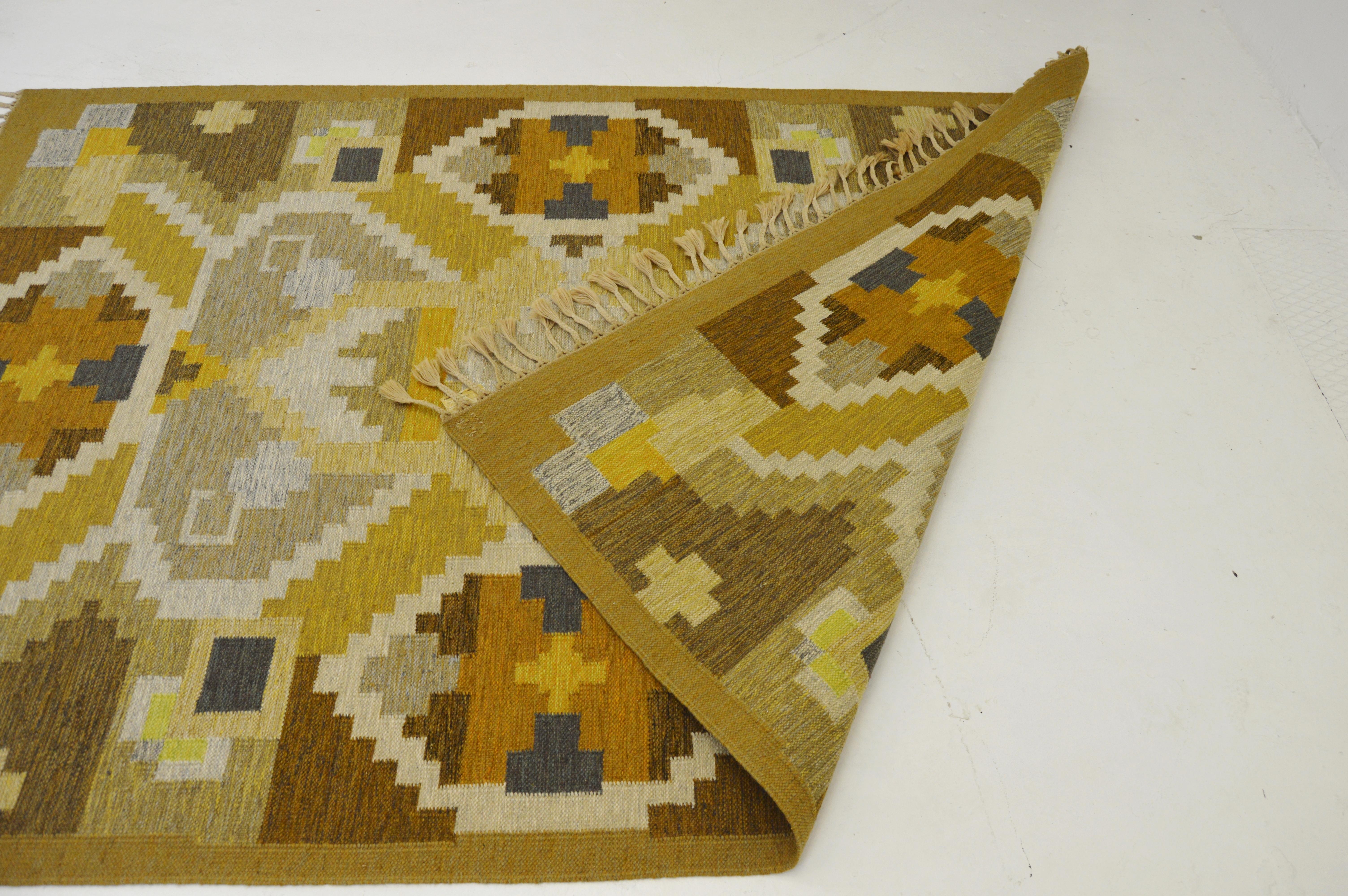 A Scandinavian Modern Rollakan flat-woven carpet.
Made in Sweden during the 1950- 1960s, midcentury period. Designer Ingegerd Silow, marked IS.

Handwoven wool. Different shades of light brown, yellow and grey are the dominant colors accompanied
