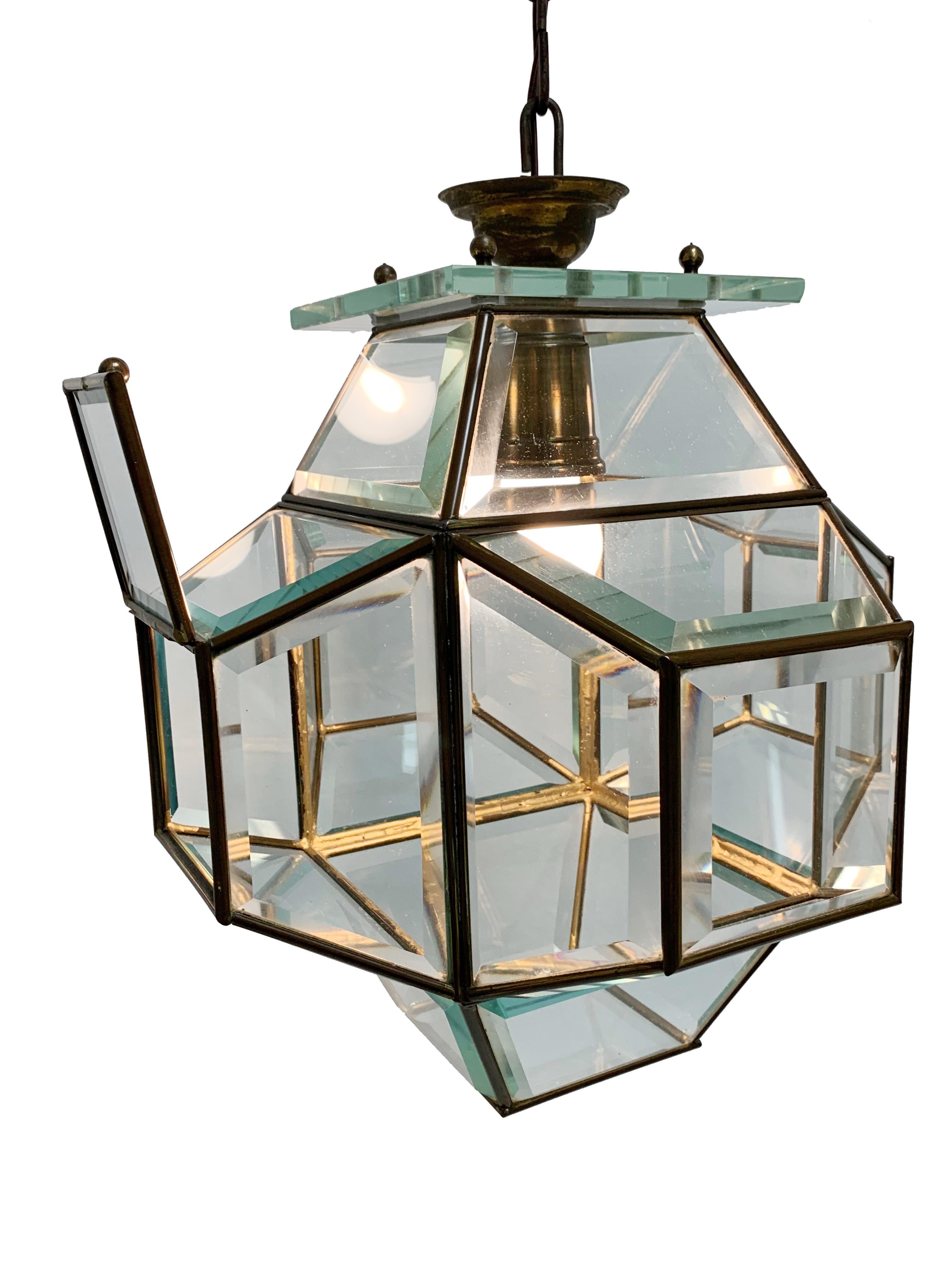 Glass and brass lantern from the 1950s attributed to Fontana Arte. Lighting of Italy
Particular and large lantern, composed of a brass frame with cut crystal glass, hanging from a thick square glass slab.
The glass is very often about 1