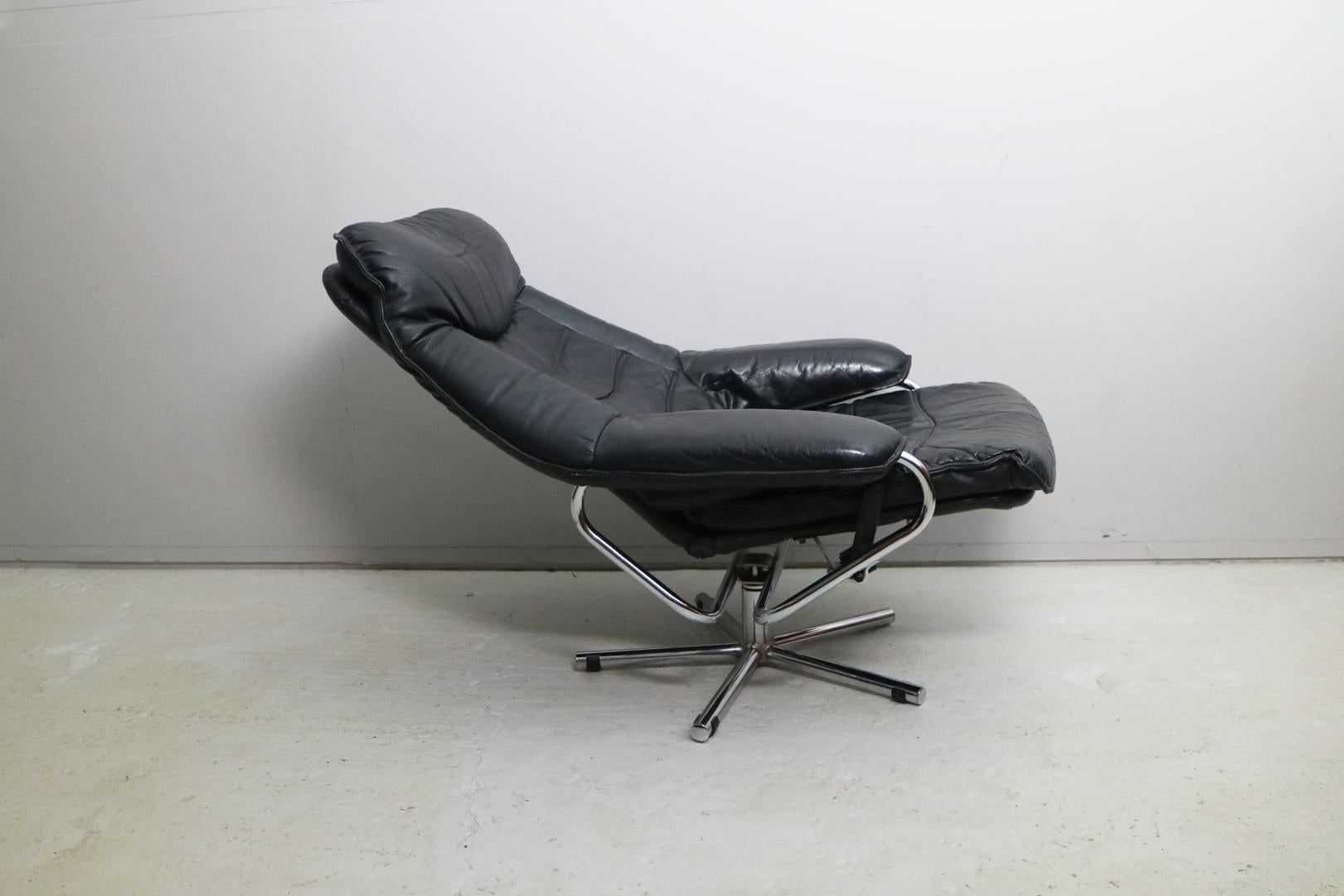 A black leather tubular framed lounge chair, made in Spjelkavik Norway by Skoghaug Industries. Most likely produced from the late 1960s-early 1970s. Features a rotating swivel base and reclining function. Can be locked using a lever to one side of