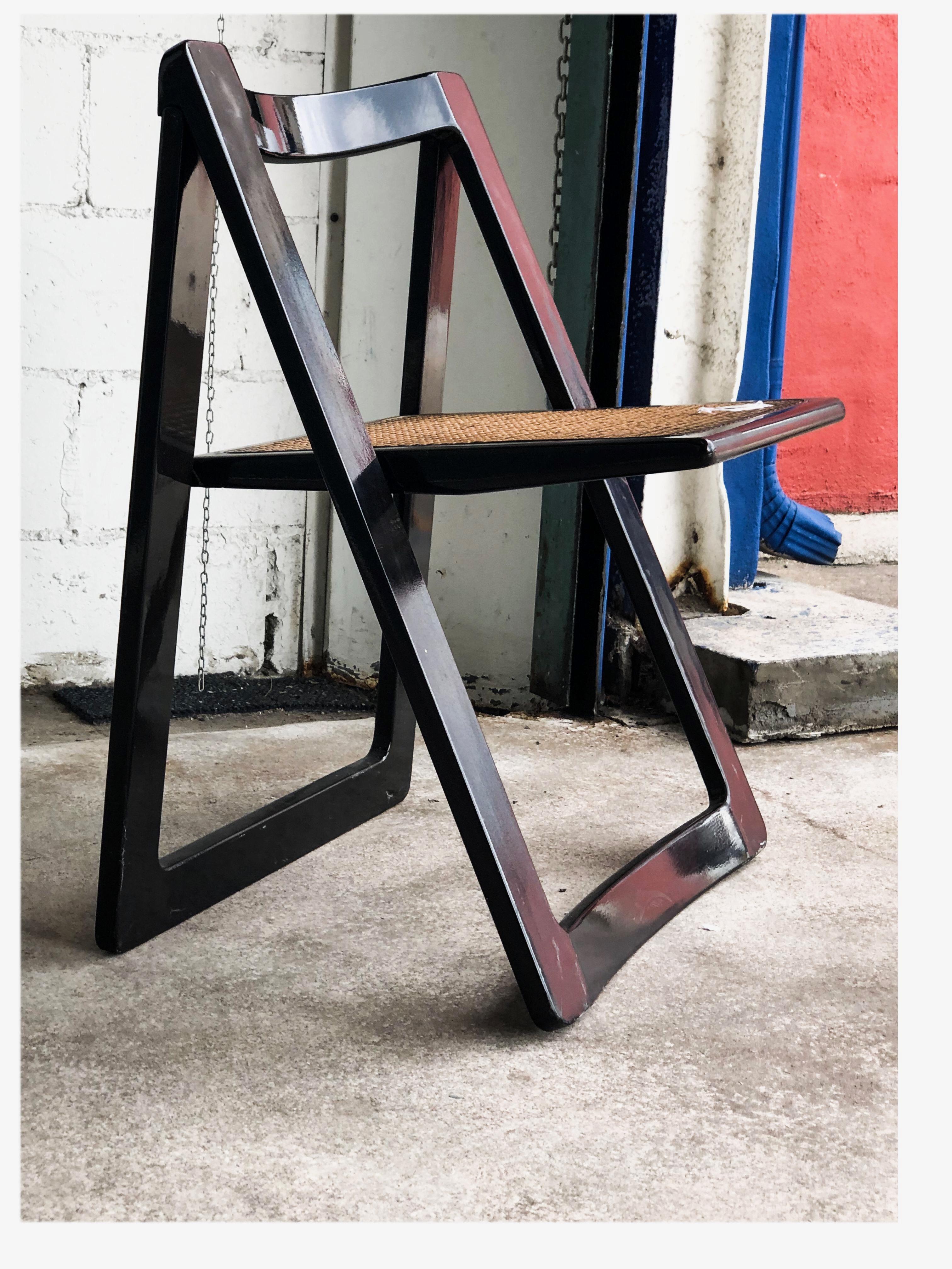 1960s Minimalist Italian black lacquer and caning folding chair “Trieste” by Aldo Jacobsen.

Gorgeous minimal 1980s Italian black lacquer folding chair with hand caned seat. Very good vintage condition. Love the angularity and graphic quality of