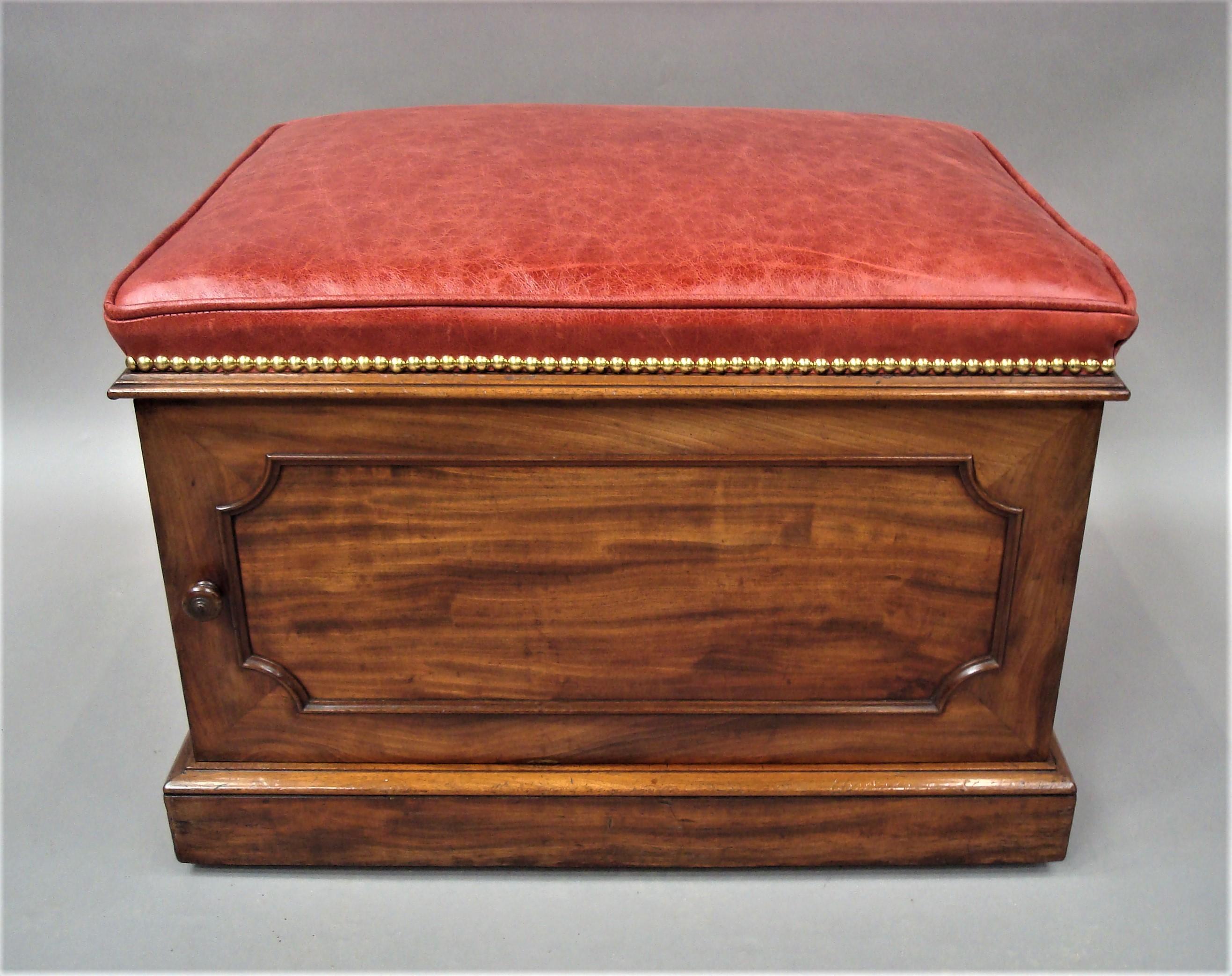 A good William IV mahogany and leather box stool of unusual form; by Doveston Bird and Hull. The rectangular padded seat, newly upholstered in good quality red hide with a piped edge and close brass studs, above a shaped mahogany moulding. The door