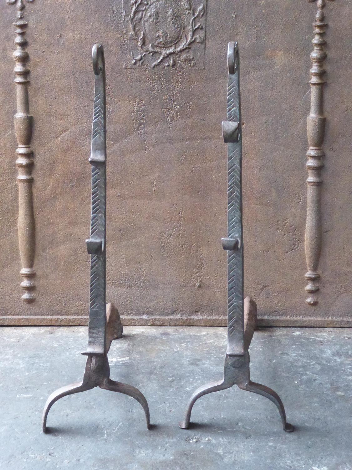 Large 17th century French andirons. The style of the andirons is Louis XIII and they are from that period. The andirons are made of wrought iron and they have a natural brown patina. Upon request it can be made black. The andirons have spit hooks to
