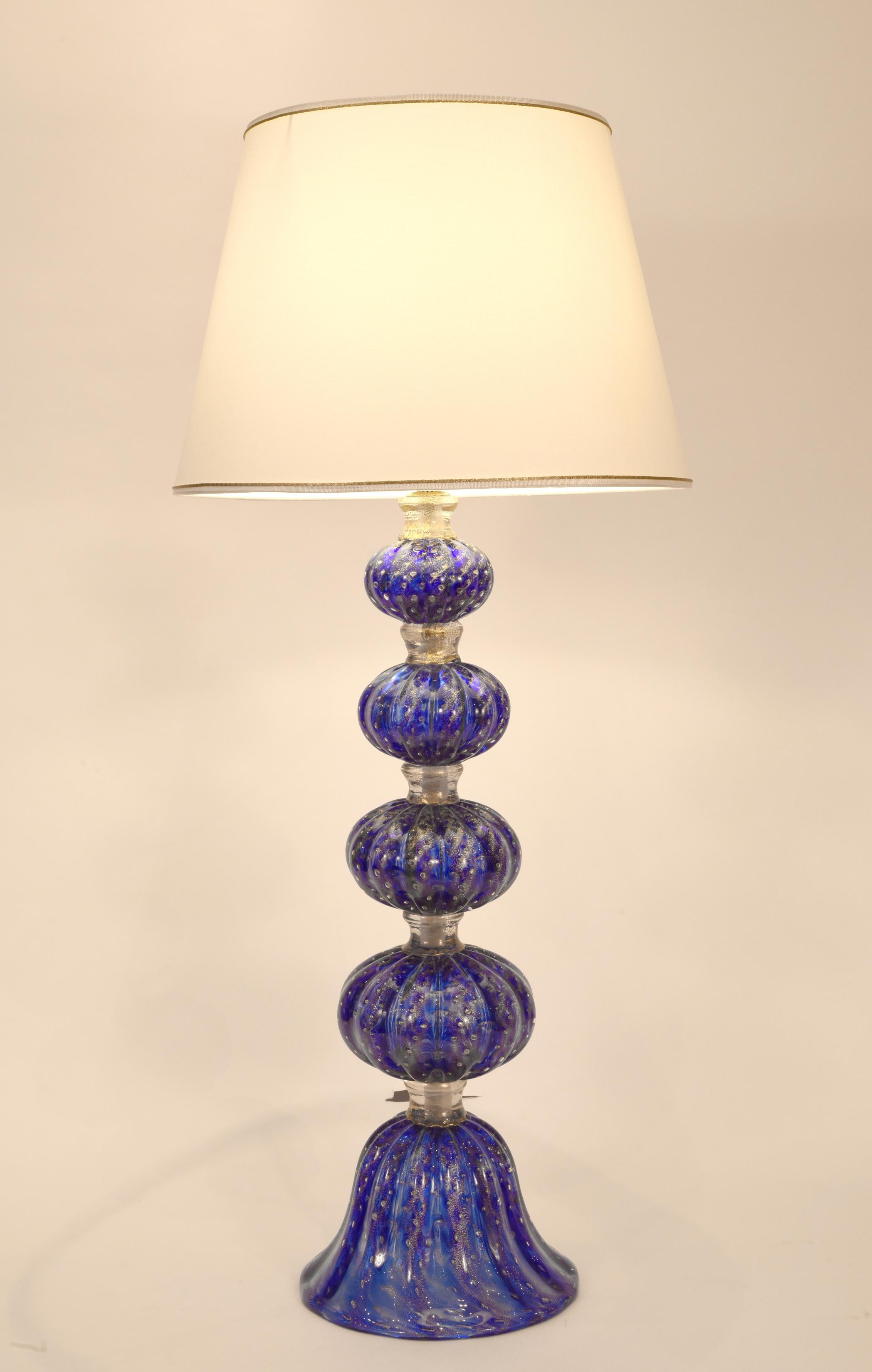 Exquisite pair cobalt blue with gold flecks Murano glass table / task lamps. Each lamp is in excellent working condition. Maker's mark undersigned on each one. Rewired for US use. Each lamps measure about 27 inches high from base to socket light