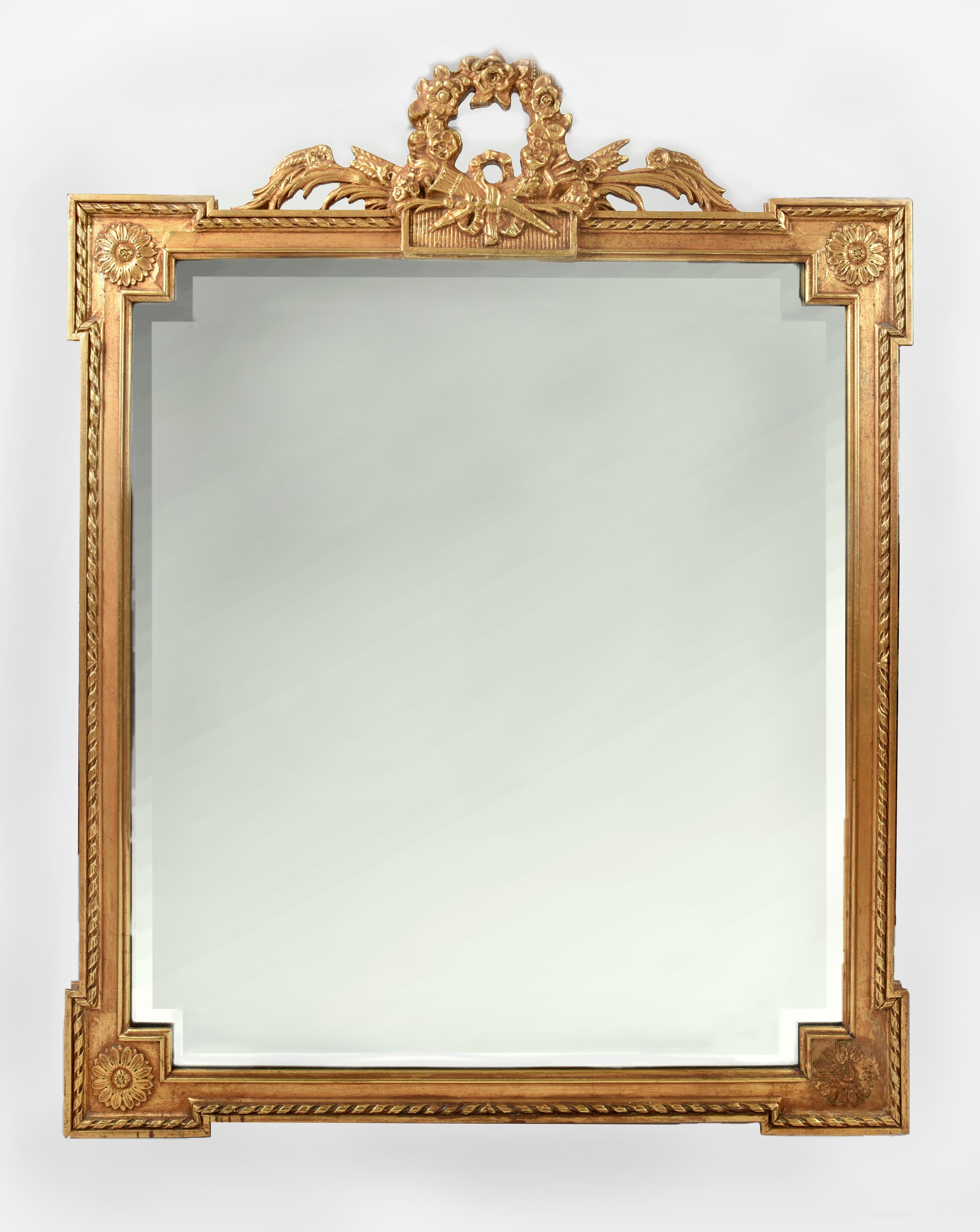 Early 20th century matching pair giltwood frame beveled hanging wall mirrors. These matching pair are just exquisite and in excellent vintage condition. Each mirror is having a beautiful wreath crests top and all around design details. Each one