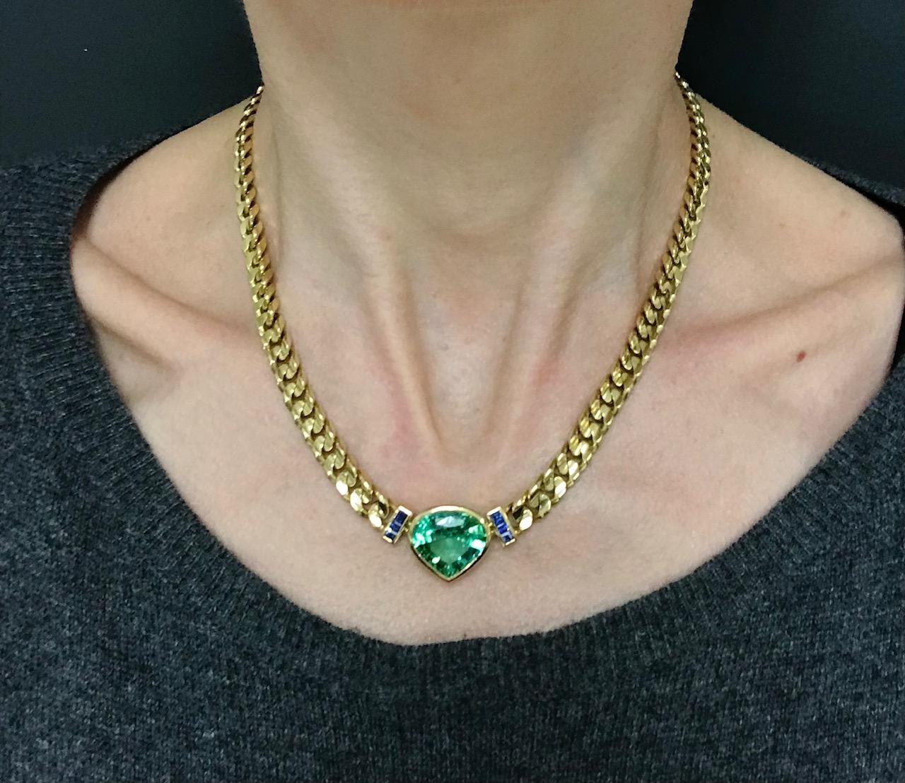 A spectacular Bulgari 18k gold chain necklace features tourmaline and sapphire. The chain is 
Every detail of this necklace is significant. The curb link chain has a curve in the middle making it look unusual.
The clasp features a bezel set diamond.