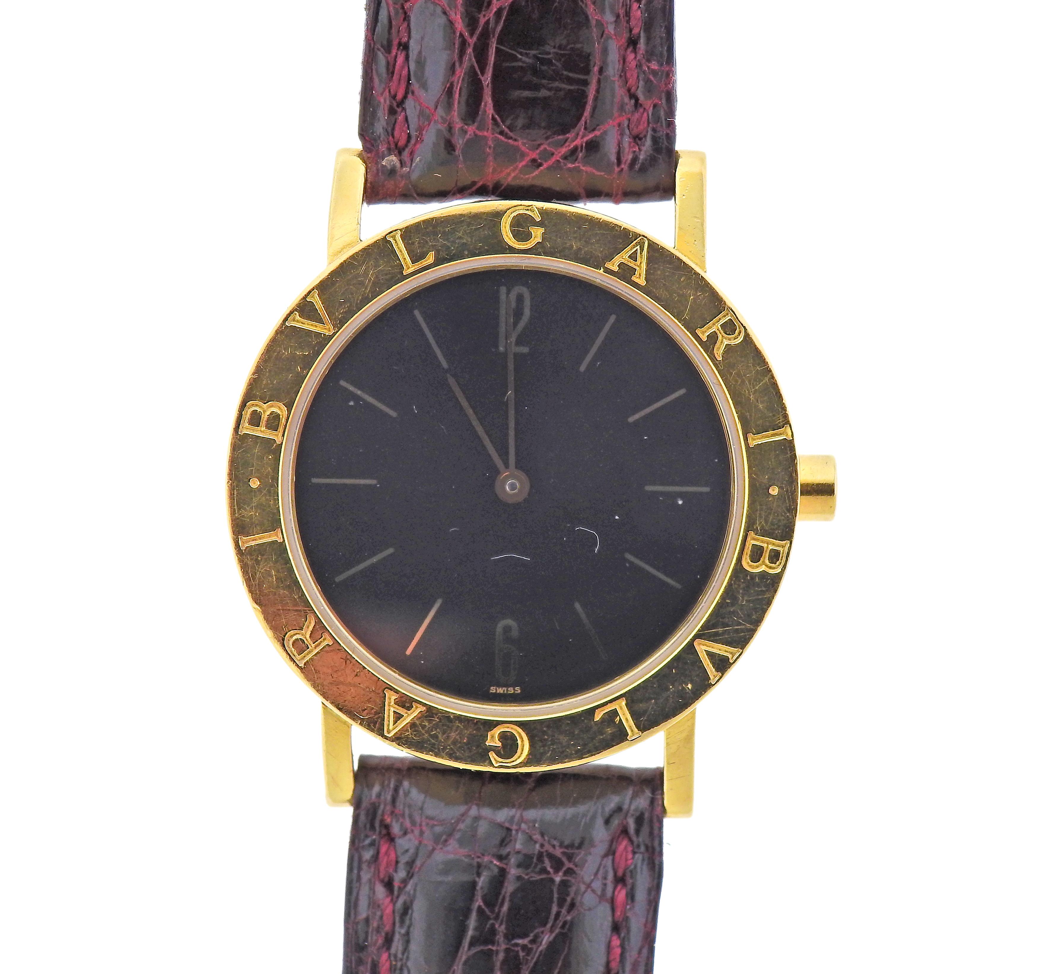 Classic 18k yellow gold Blvgari watch, with black dial, featuring gold stick markers. With leather band and  18k gold buckle. Case is 33mm in diameter, Bracelet is 6 7/8