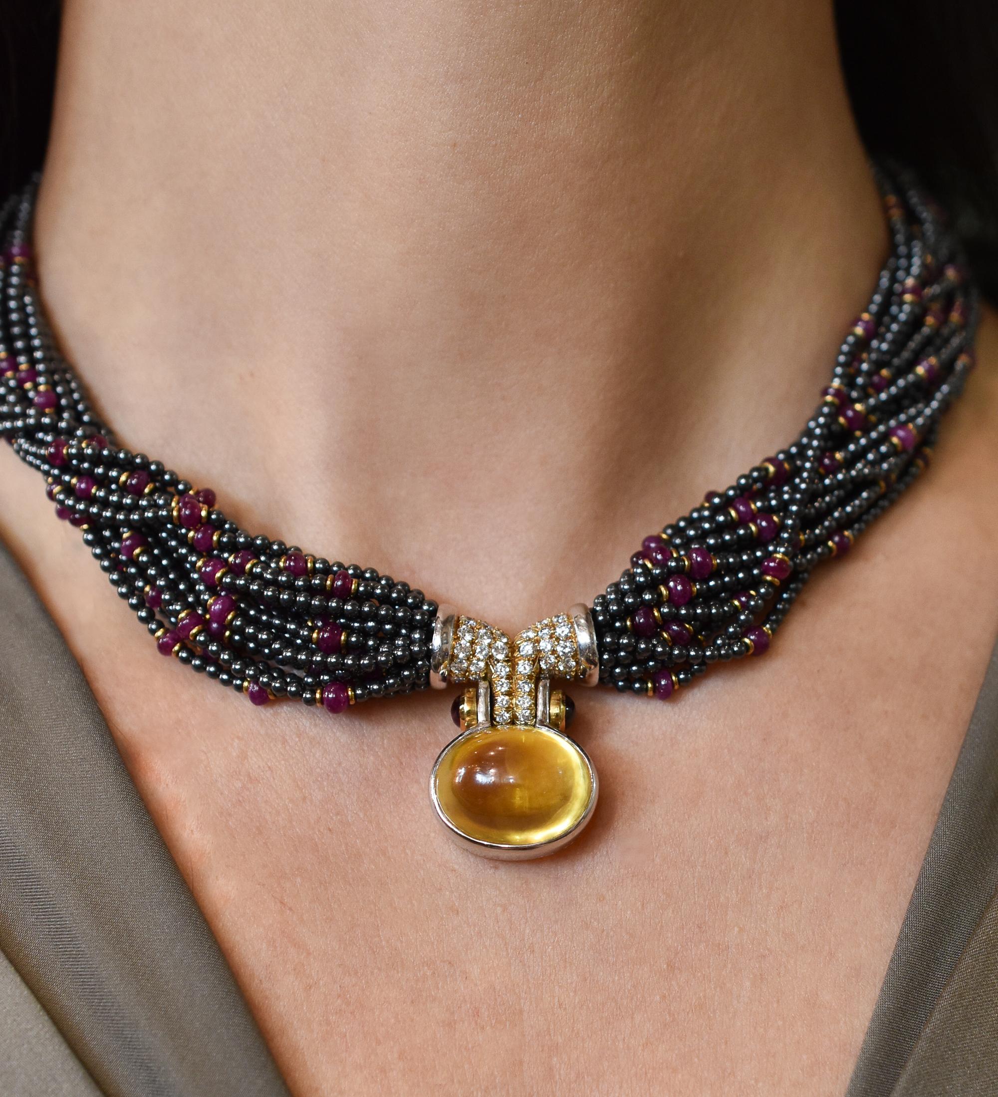 A magnificent Bulgari Gem-set and Diamond Torsade Necklace mounted in 18k  yellow gold. Made in Italy, circa 1980.

The necklace composed of a multi-strand ruby and hematite torsade, centering a cabochon yellow sapphire pendant weigh 43.53 carats,