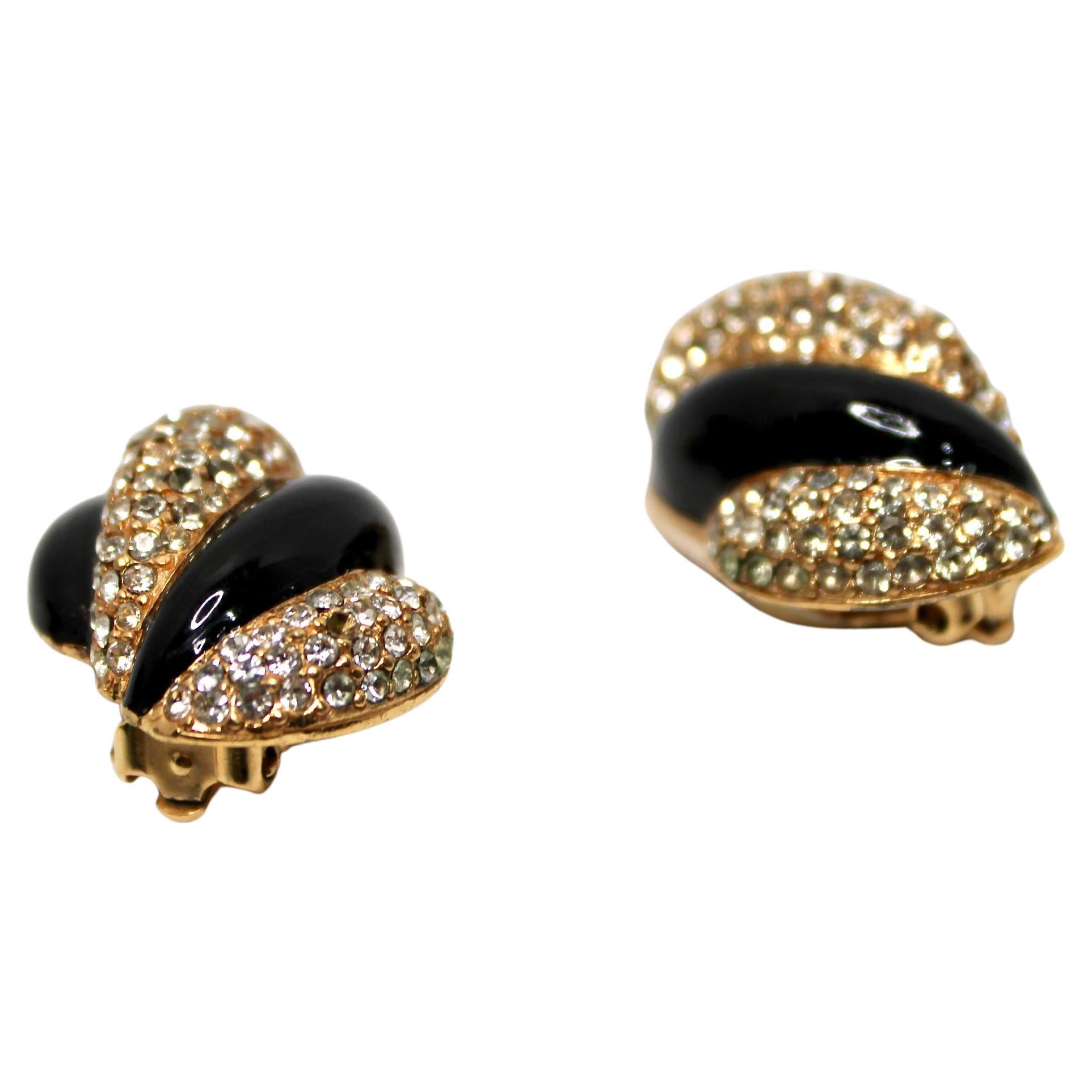 Gli orecchini a clip con smalto nero placcati in oro 18k di ispirazione bulgara, risalenti agli anni '70 circa, sono uno splendido esempio di artigianato di gioielleria vintage. Realizzati con una forma a conchiglia attorcigliata, questi orecchini