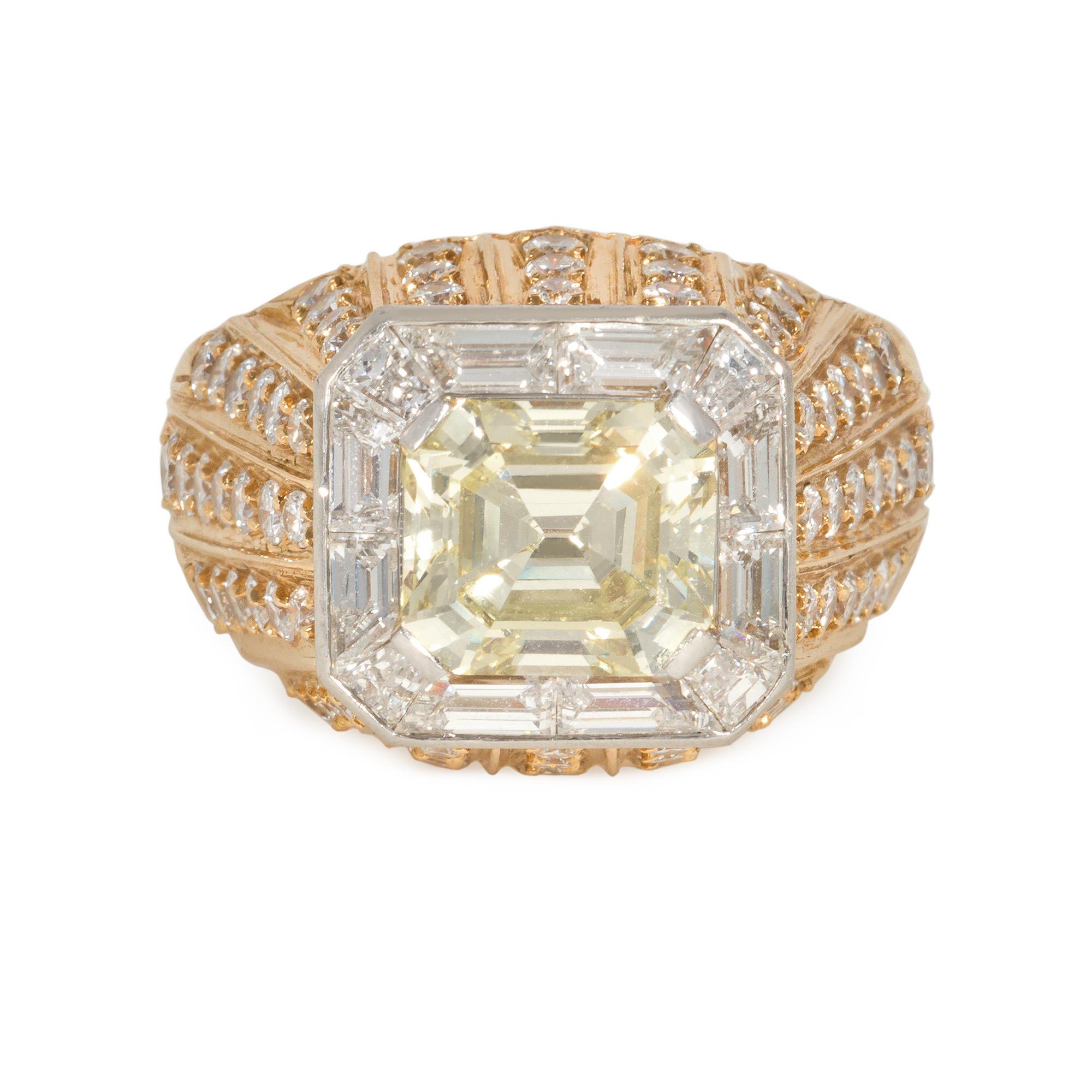 An estate yellow and white diamond and gold cocktail ring centering on a natural, fancy yellow emerald-cut diamond in a white diamond channel-set surround, with a raised rose gold mount embellished with striped, radiating white diamonds, in 18k.