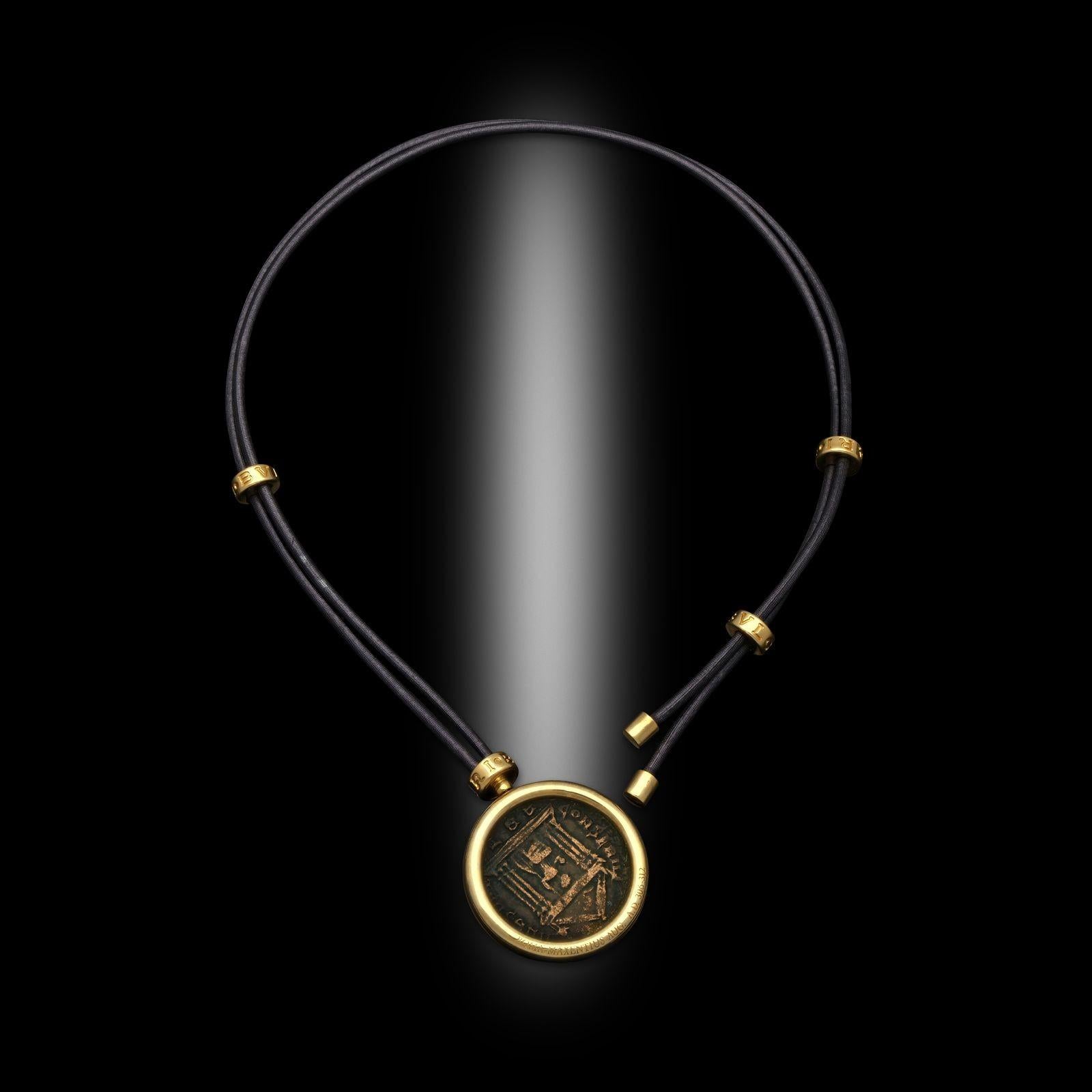 A vintage Monete pendant by Bulgari, 1990s. This necklace has a single bronze ancient Roman coin set into a rounded 18ct yellow gold bezel setting. The coin is suspended from a black leather cord which can be adjusted by three moveable 18ct yellow