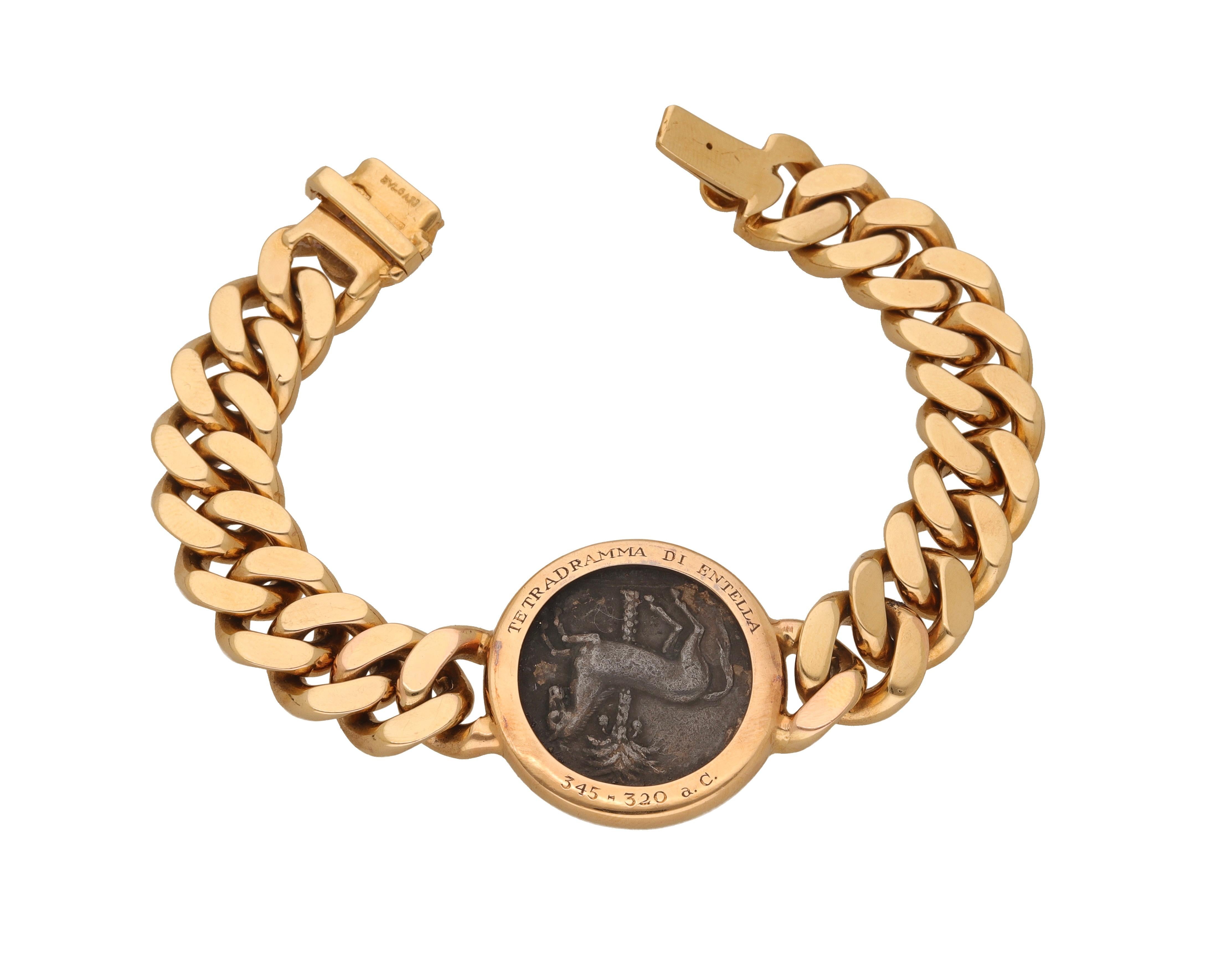 18 kt. gold bracelet with antique coin signed Bulgari, from the MONETE collection.
The bracelet is made of yellow gold groumette links with an antique silver coin in the center depicting on the front the head of Arethusa, on the back a prancing