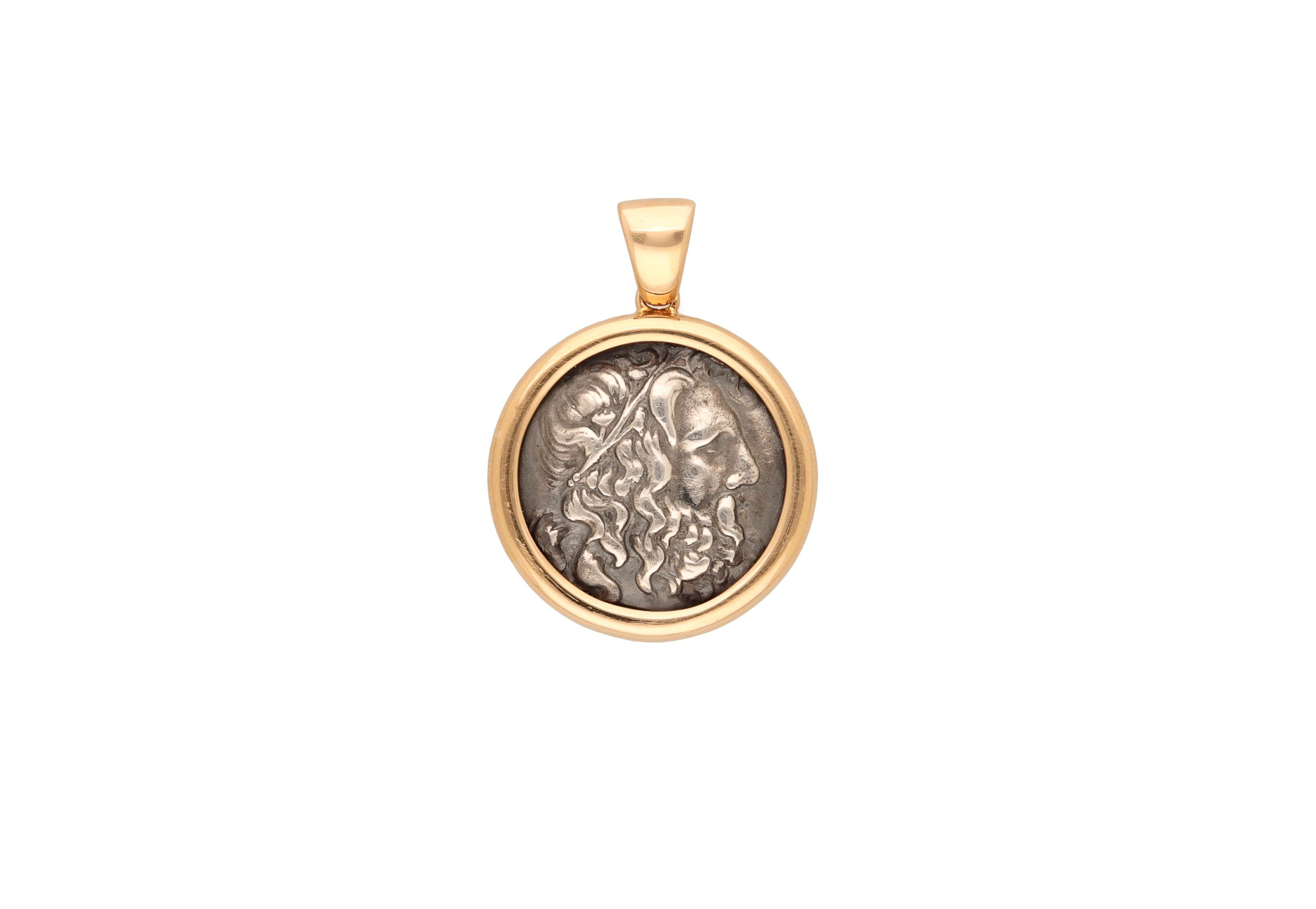 18 kt. yellow gold pendant with an ancient coin signed by Bulgari.
Diameter 3.15 cm. 
Coin: Tetradrame Antiochus IV, 215-164 A.C.
Comes with the original box.
1980 ca.
Weight gr. 27.50
