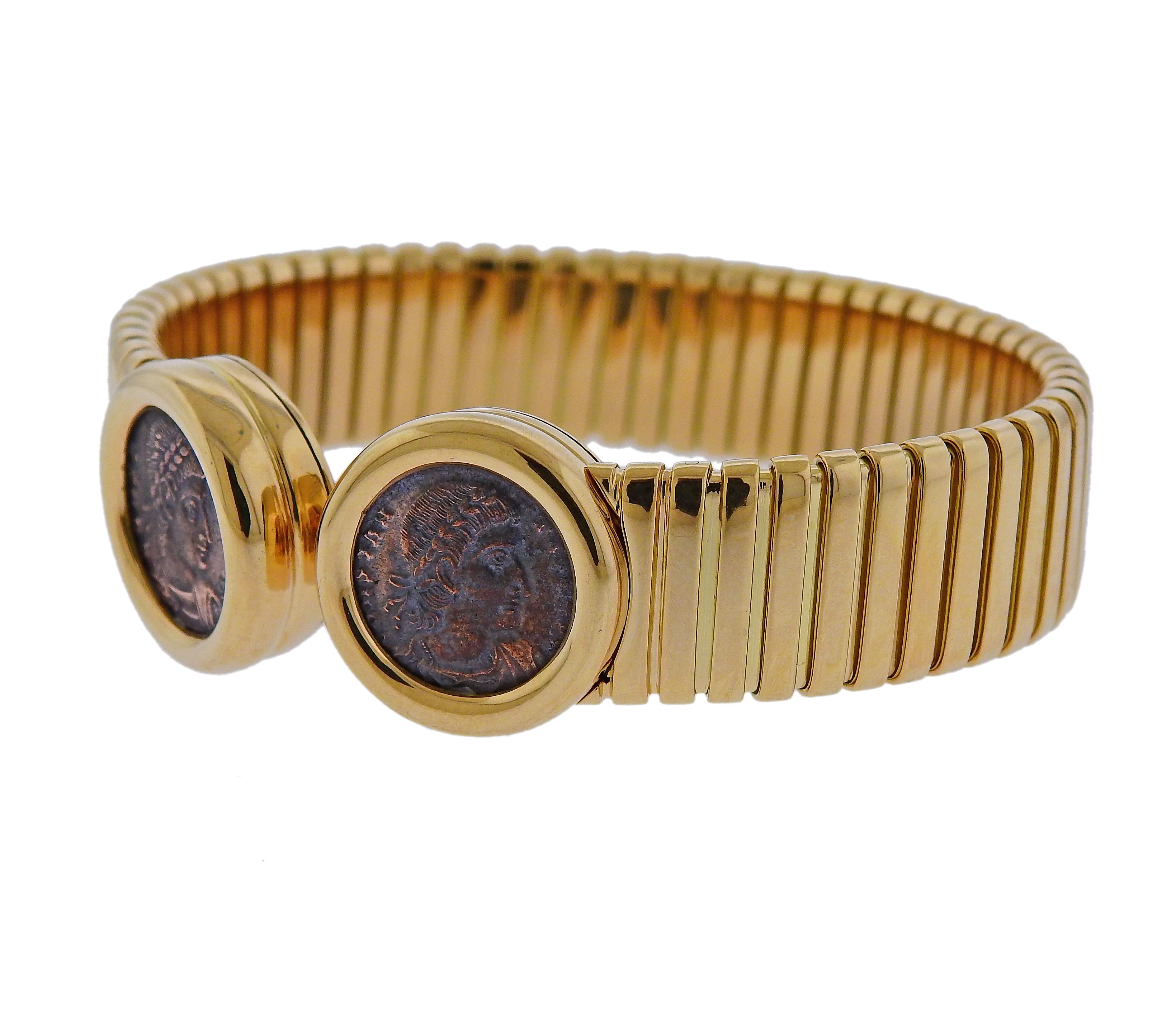 Iconic 18k yellow gold cuff bracelet, crafted by Bvlgari for Monete collection, set with two ancient coins. Bracelet will fit up to 7.5