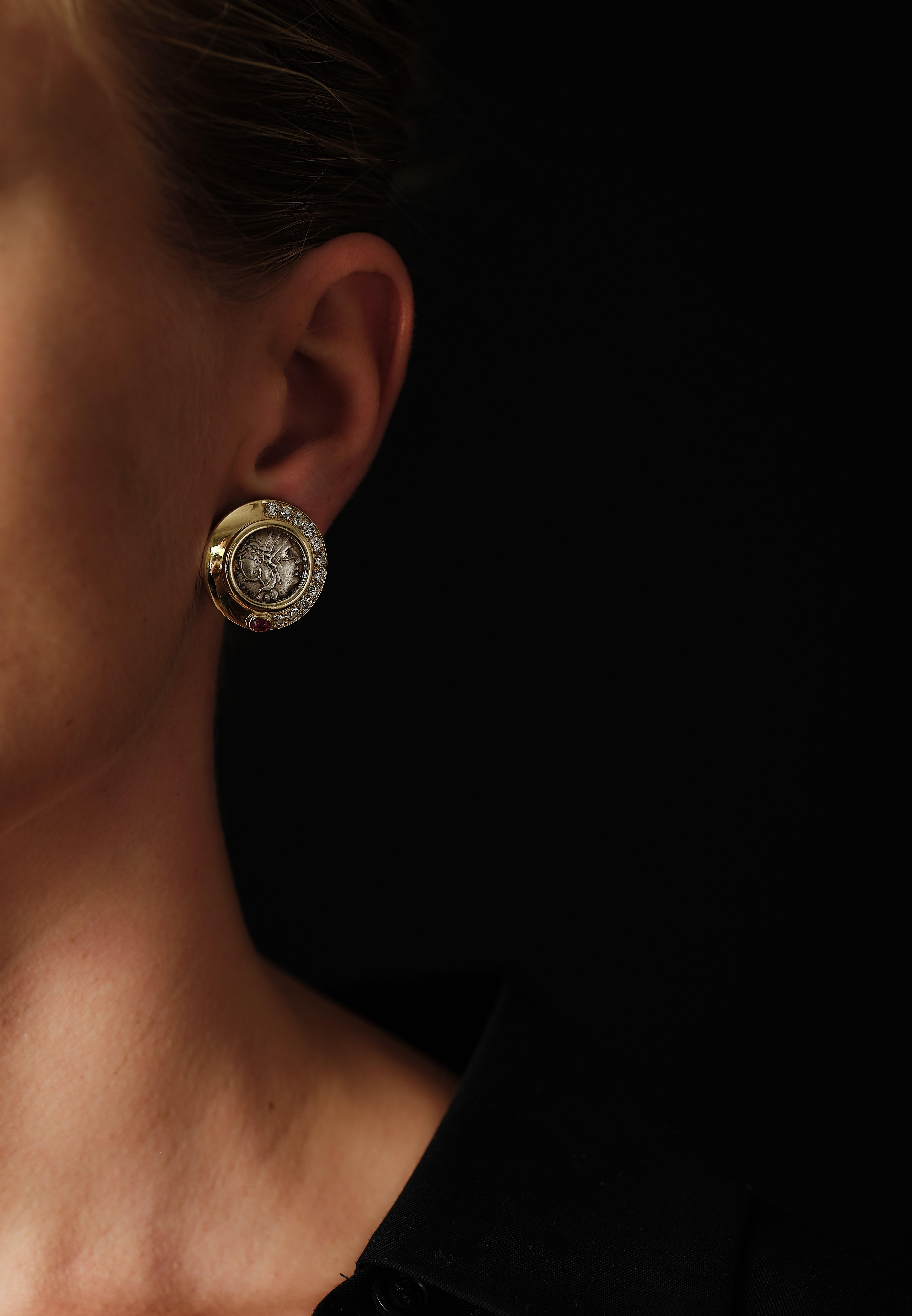BVLGARI Monete 

Two ancient, 2157  year old, silver denarios, set in a 18 karat gold frame with a half moon of 11 brilliant cut diamonds finishing with a strongly saturated cabochon ruby. Historical. Graphical. Elegant. Outstanding!  

Gross weight