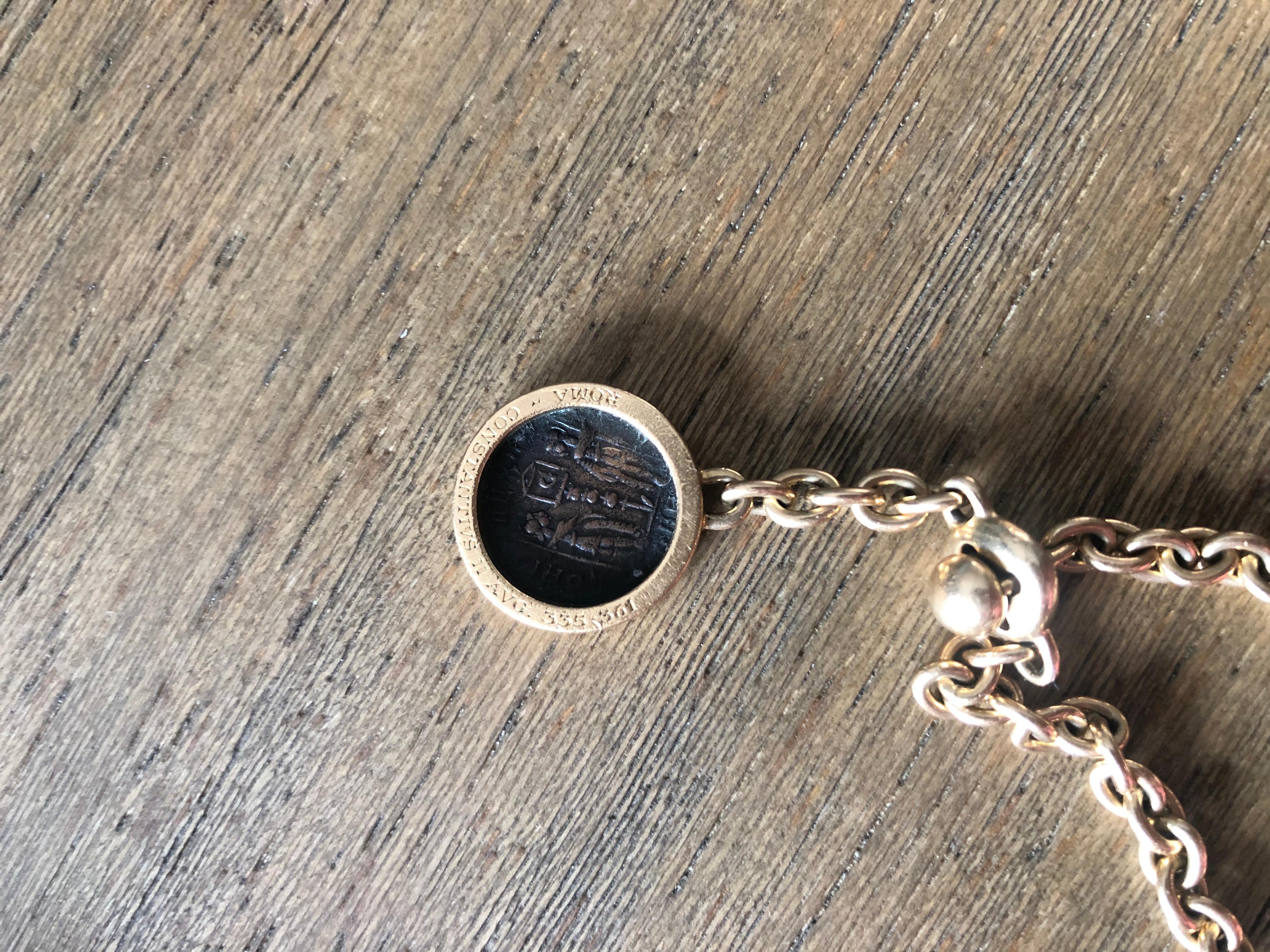 Stamped Bulgari / Bvlgari 18-karat yellow gold key chain with ancient Roman coin charm, circa 1970. The clasp is cleverly engineered to require the long and thin link to pass through it in order to open or close it. Pulling on the links