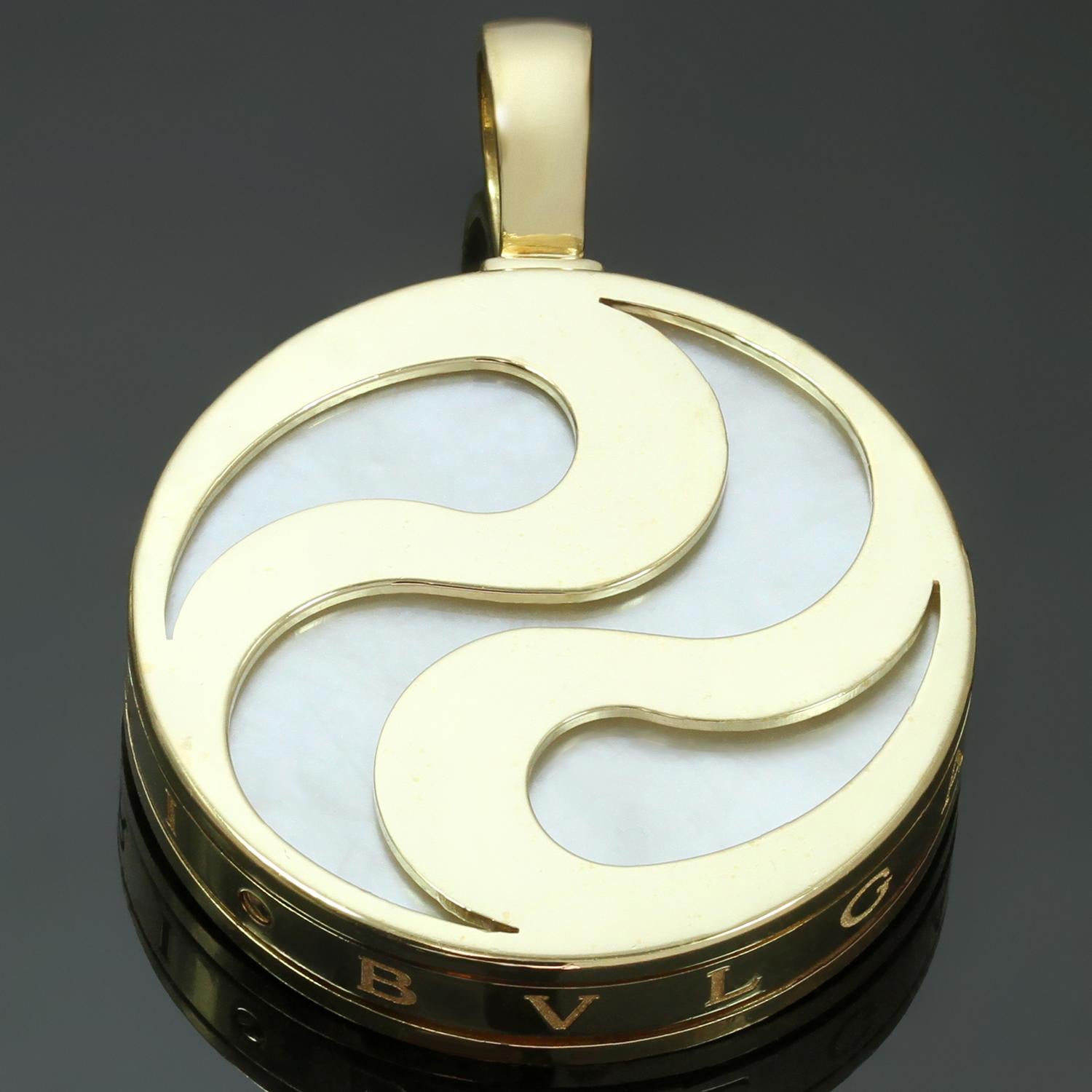This chic and playful Bulgari spinning pendant features a swirling ying yang design crafted in 18k yellow gold and inlaid with mother-of-pearl. The pendant is inscribed with the Bvlgari logo. Made in Italy circa 1990s. Measurements: 1.06
