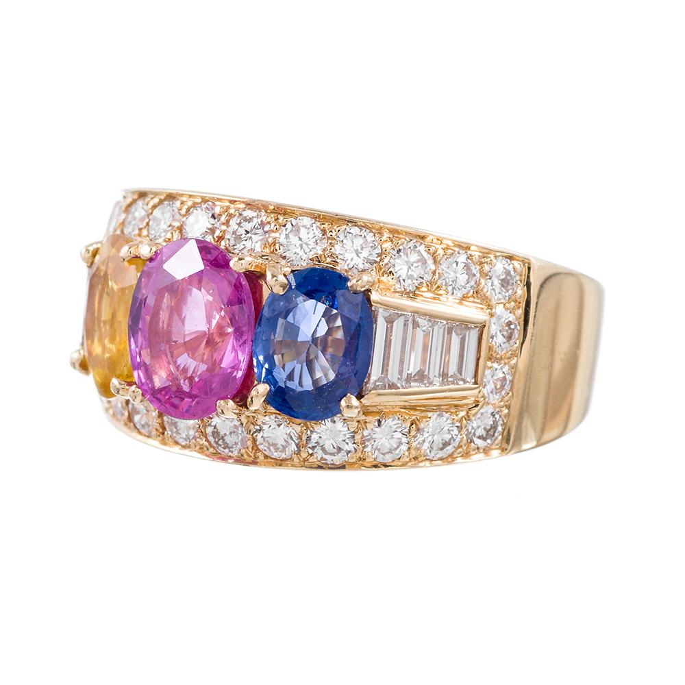 18k yellow gold ring set with a trio of brightly-colored oval sapphires: a cornflower blue, a vibrant pink and an intense yellow are complimented by Bulgari's signature combination of round- and baguette diamonds. In total, the three sapphires weigh