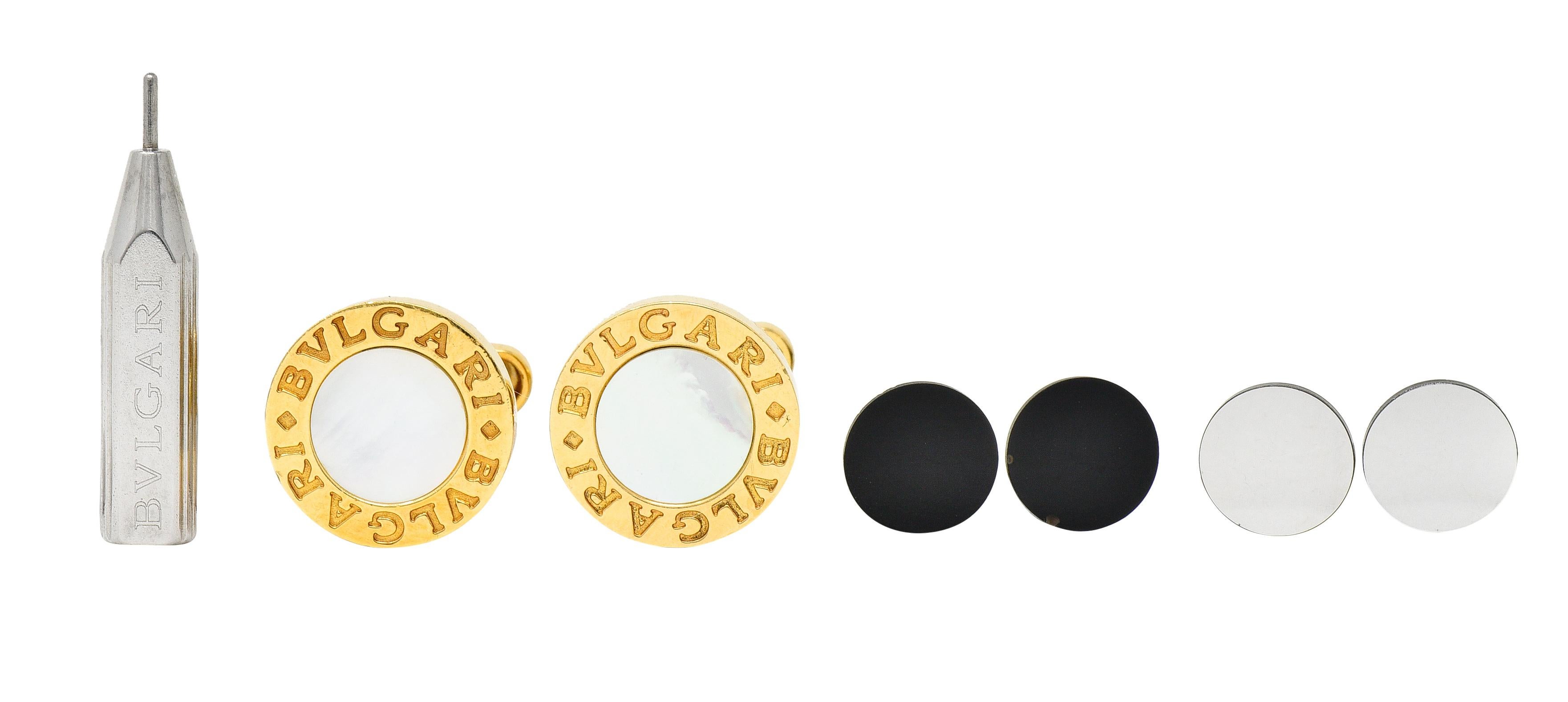 Leverback cufflinks terminate as a hinged bar and feature 16.0 mm round forms. Centering flushly inlaid 10.0 mm round tablets of onyx, white mother-of-pearl, and/or steel. Opaque black, strongly iridescent, and with a metallic luster. Changeable via
