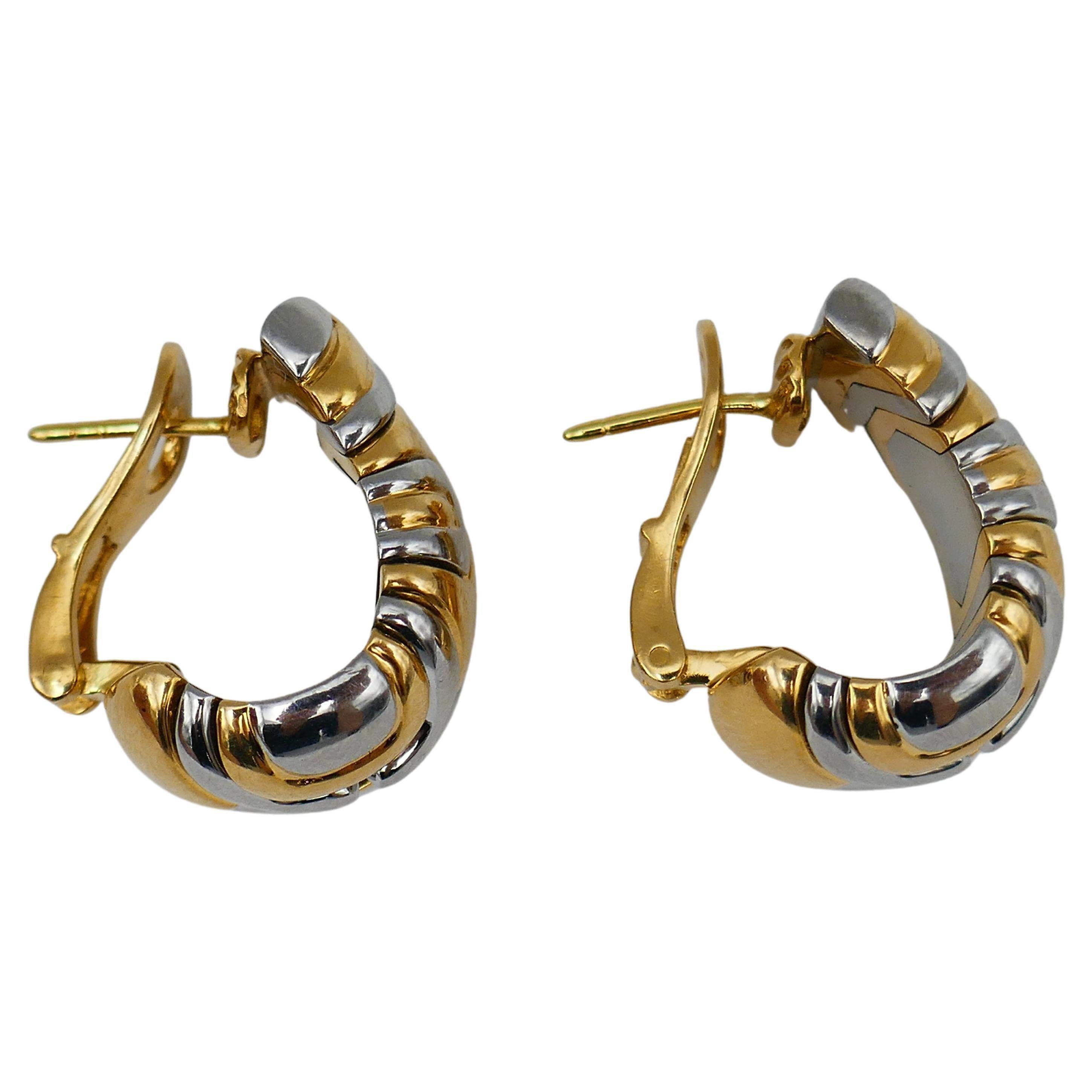 Ein Paar Bulgari Alveare Huggie-Ohrringe aus 18 Karat Gold und Edelstahl. Gestempelt mit Bulgari-Herstellermarken, einer Punze für 18-karätiges Gold, dem Herstellungsjahr (1988) und einer Seriennummer.
Abmessungen: 7/8
