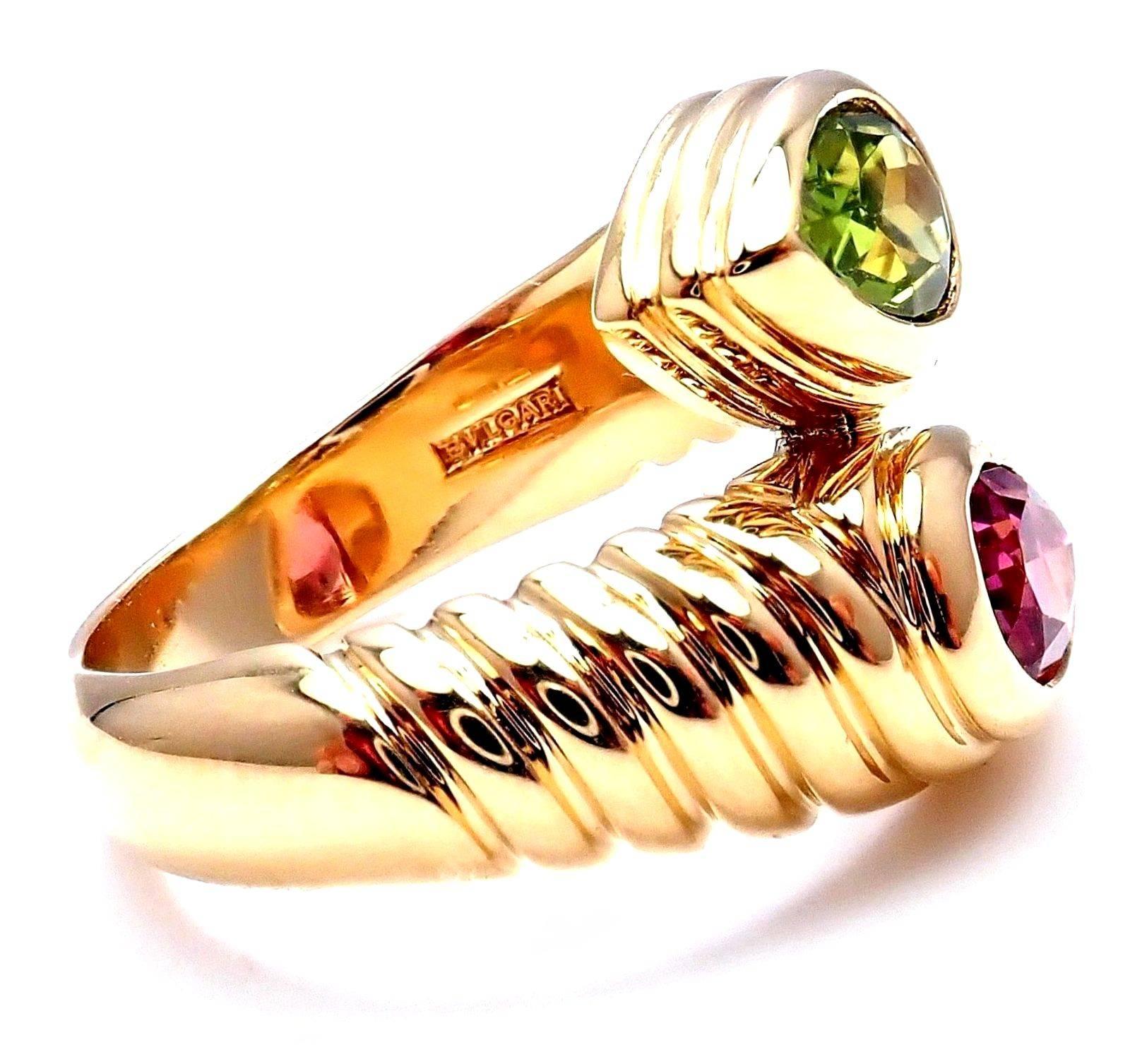18k Yellow Gold Pink And Green Tourmaline Doppio Bypass Band Ring By Bulgari. 
With 1 Pink Tourmaline 5mm x 7mm
1 Green Tourmaline 5mm x 7mm
Details:
Ring Size: 6.5 (resize available)
Width: 15mm
Weight: 11.4 grams
Stamped Hallmarks: Bvlgari