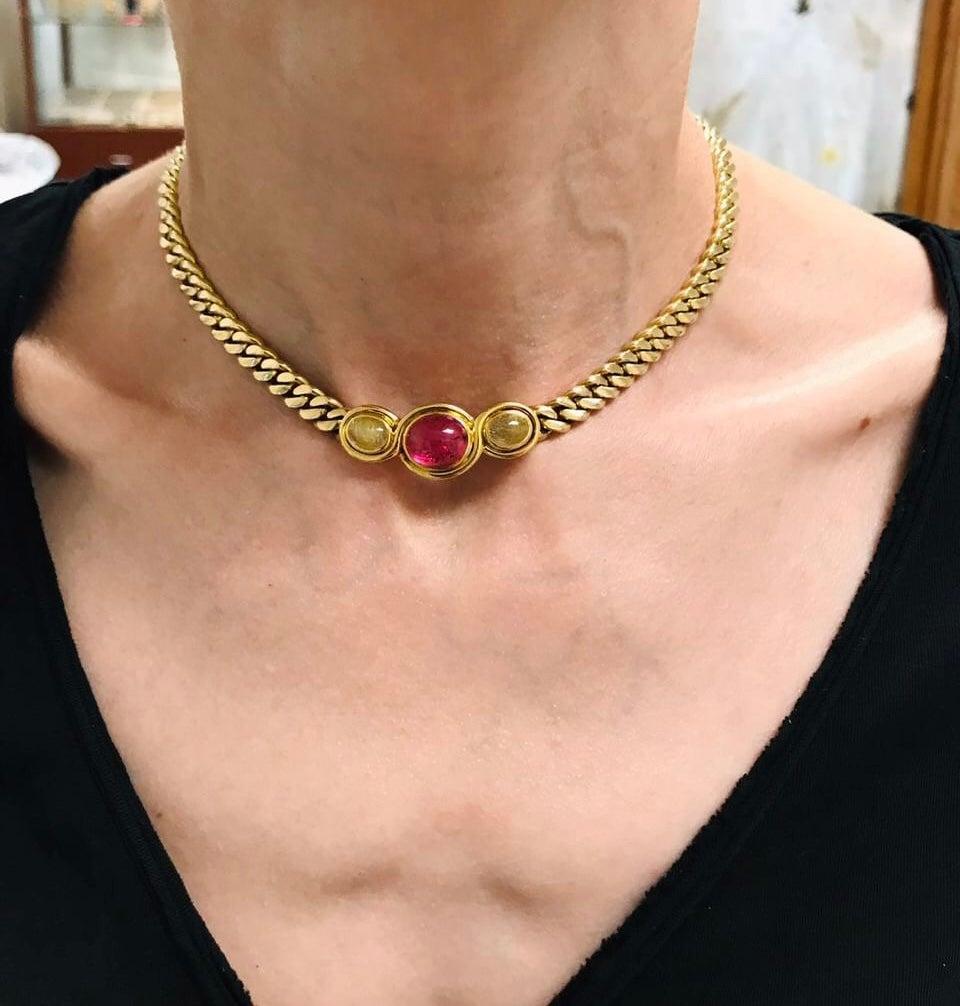 A classic Bulgari gold chain necklace with gemstones. Features three gorgeous gems: a pink tourmaline in the center and two rutilated quartz on the sides. All the gemstones are cabochon cut, bezel set. Gold quartz's color pairs beautifully with the