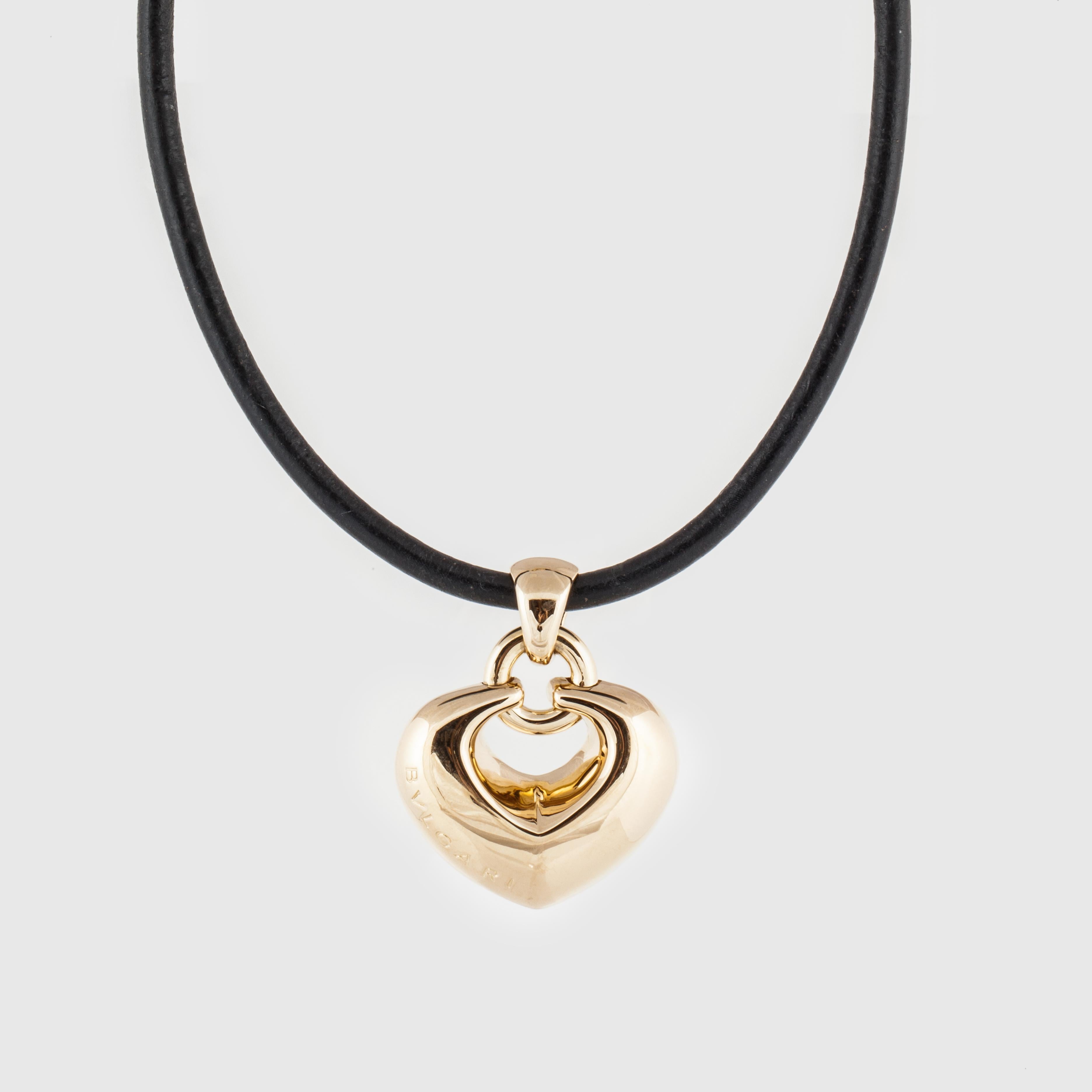 Bulgari necklace features an 18K yellow gold puffy heart on leather cord.  The front of the heart is marked 