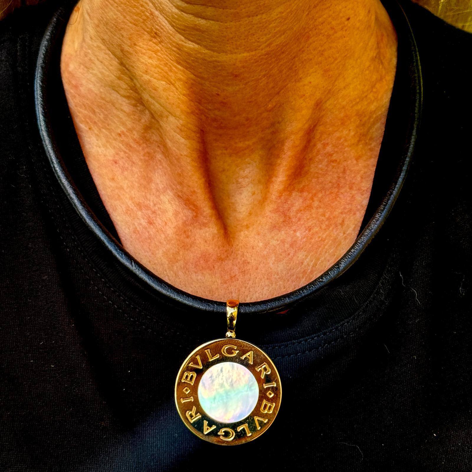 This sophisticated Bvlgari reversible Tondo necklace offers versatility and elegance in one striking piece. The 35mm round pendant, crafted from 18k yellow gold and stainless steel, features luminous mother-of-pearl on one side and sleek black onyx